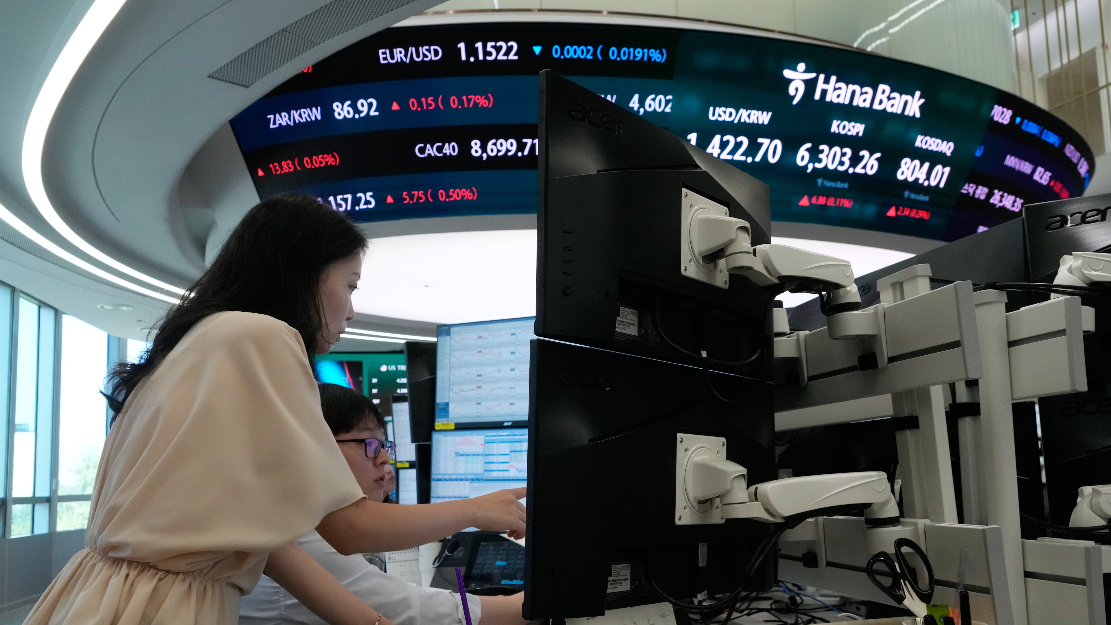Currency traders watch monitors at the foreign exchange dealing room of the Hana Bank headquarters in Seoul, South Korea, Friday, Aug. 7, 2026. (AP Photo/Ahn Young-joon)