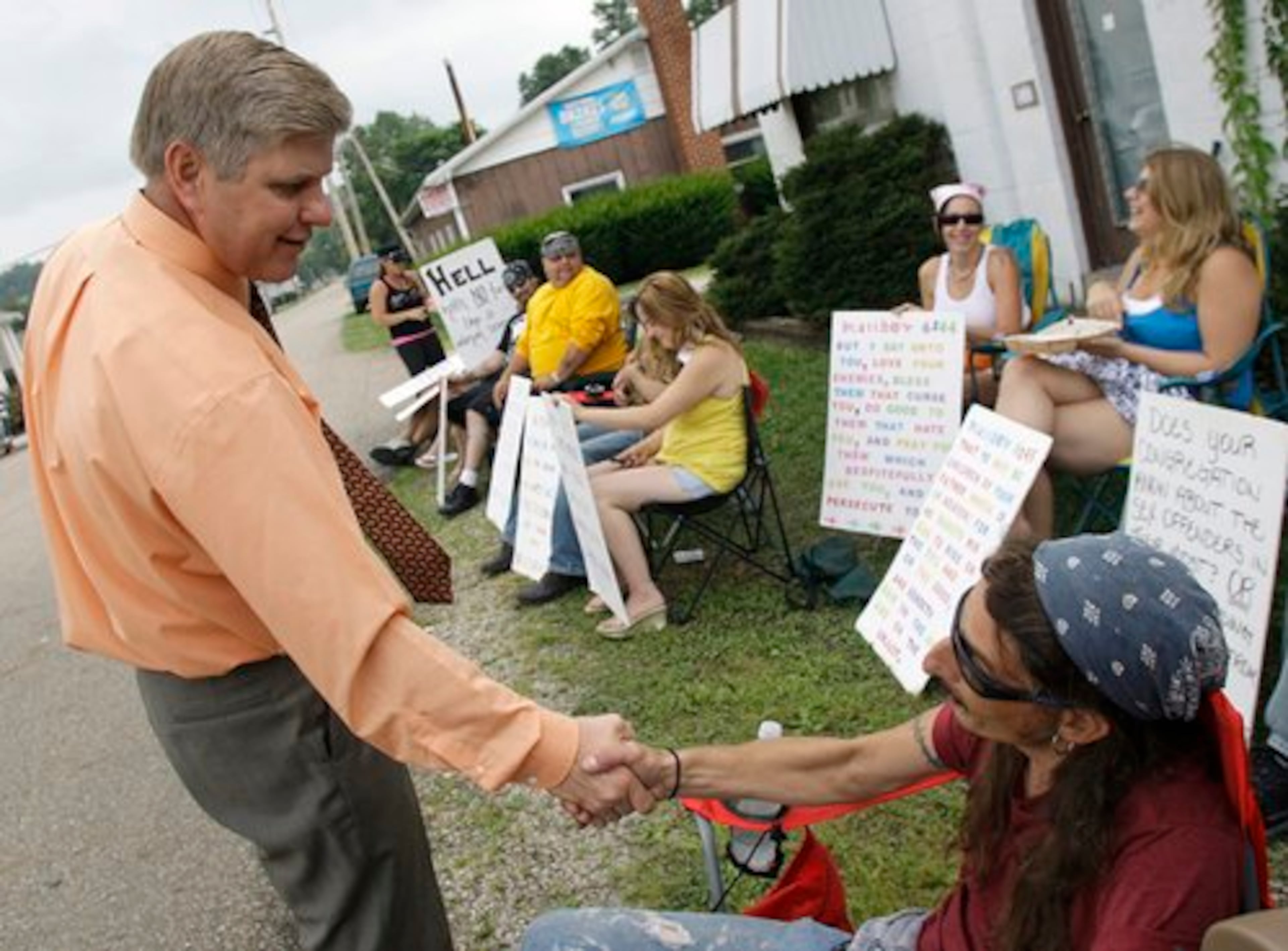 Pastor Bill Dunfee, left, of New Beginnings Ministries Church, greets supporters of The Fox Hole strip club as they protest against his church in Warsaw, Ohio. Members of the church, about nine miles from the club, have picketed the business, and strippers from the club have, likewise, picketed the church.