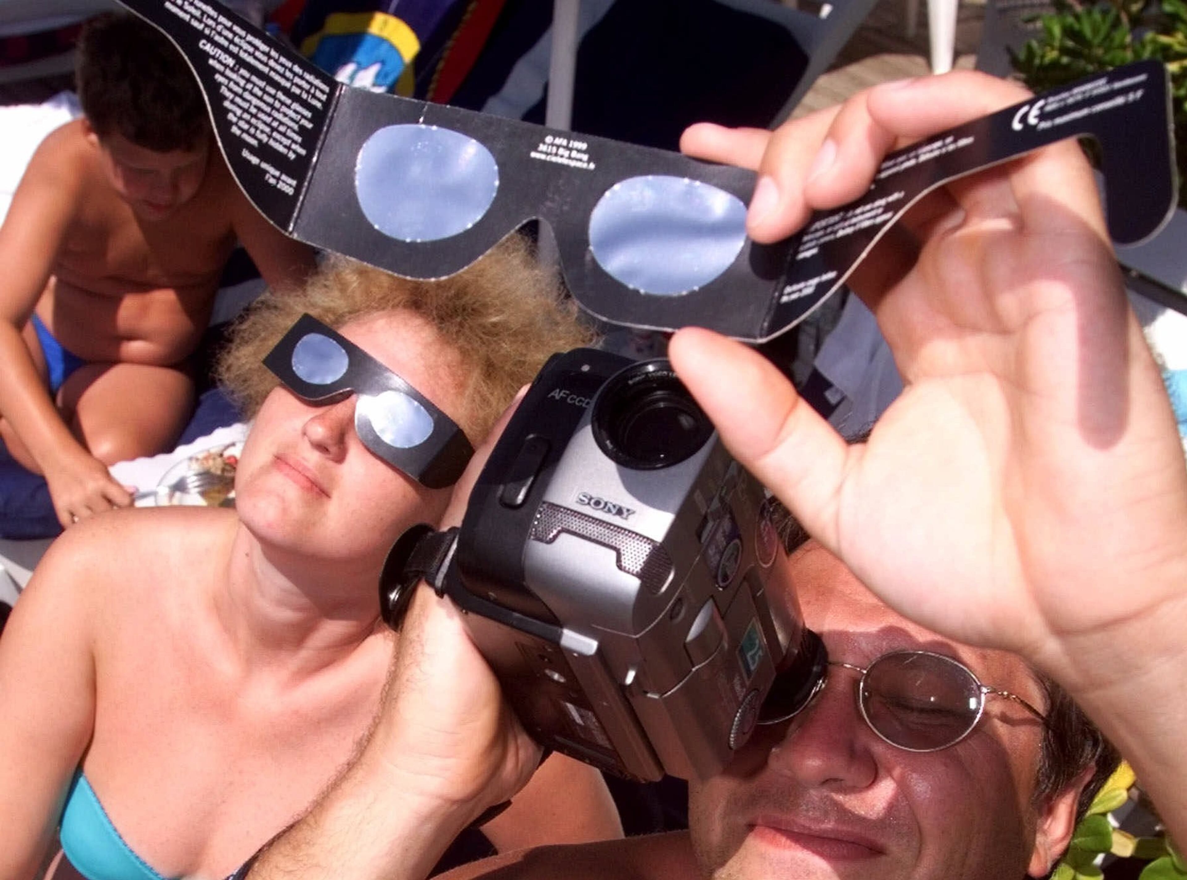 A vacationer videos the partial solar eclipse from the beach in Nice, France, Wednesday, Aug. 11, 1999. The moon smothered the light of the sun Wednesday as the last total solar eclipse of the millennium swept across Europe toward the Bay of Bengal. (AP Photo/Lionel Cironneau)