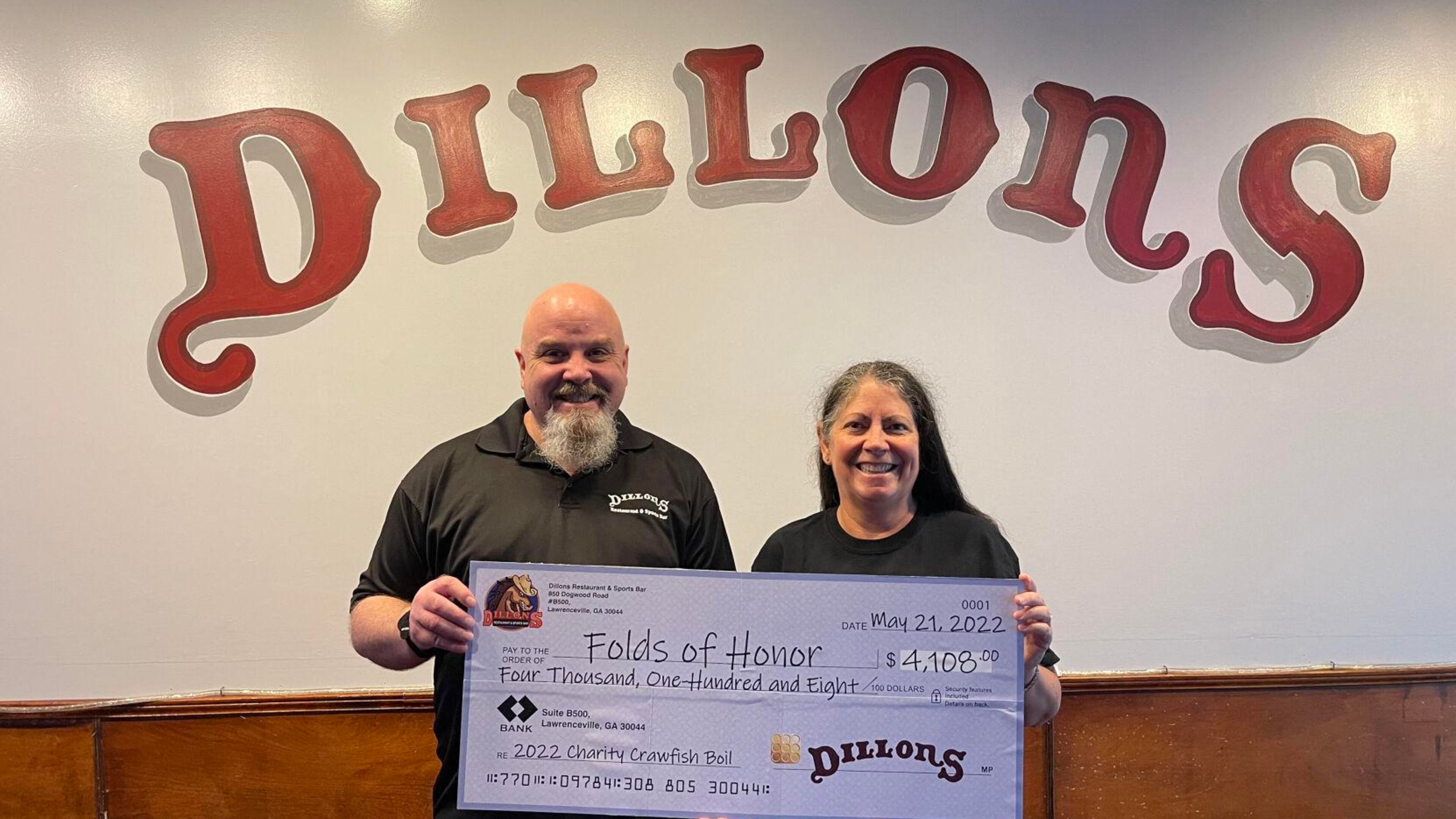 Dillons general manager Daniel Maloney and owner Donna Staton hold a replica check of more than $4,000 that was presented to Folds of Honor Georgia. (Handout)