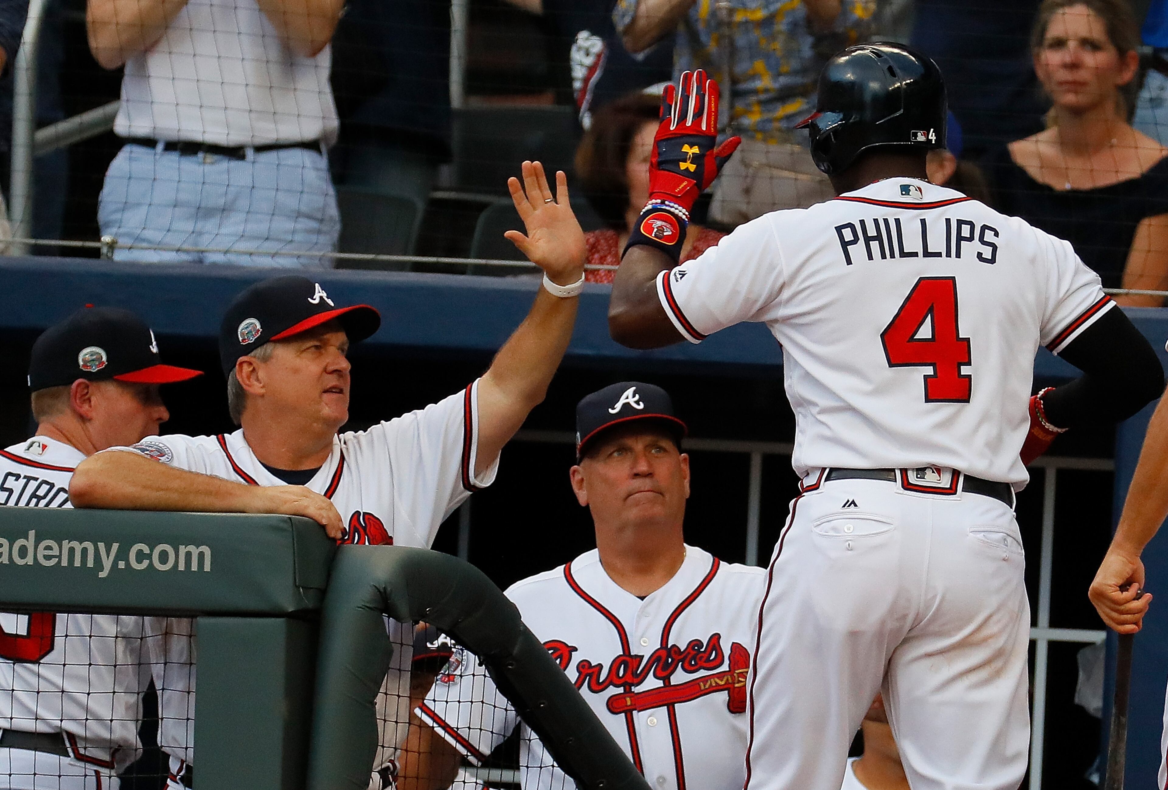 ATLANTA, GA - JUNE 23: Brandon Phillips #4 of the Atlanta Braves reacts with hitting coach Kevin Seitzer #28 and manager Brian Snitker #43 after hitting a solo homer in the first inning against the Milwaukee Brewers at SunTrust Park on June 23, 2017 in Atlanta, Georgia. (Photo by Kevin C. Cox/Getty Images)
