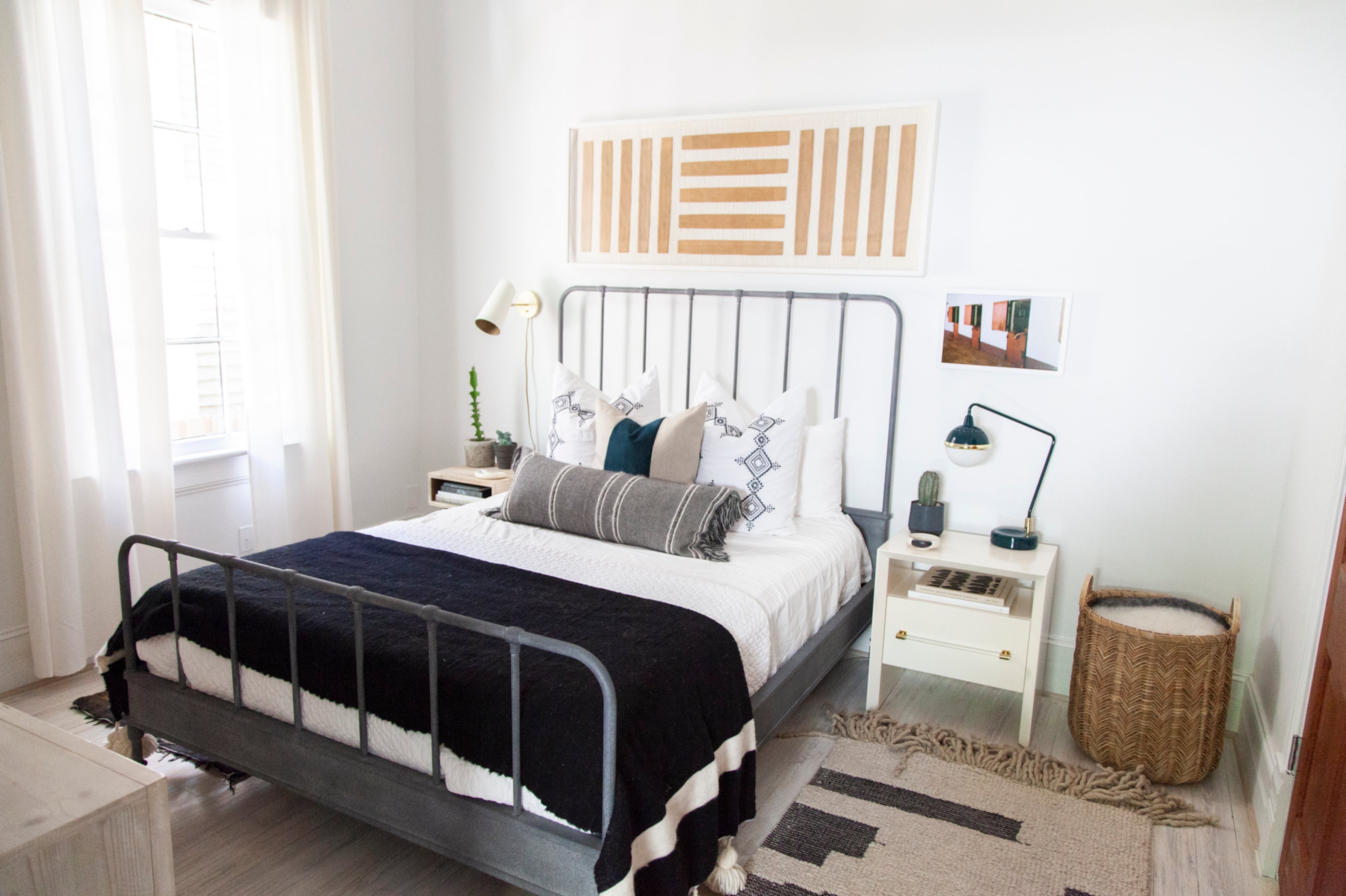 The homeowner has a background in merchandising at Anthropologie, which was the source for the nightstands in the guest bedroom flanking a metal bed from RH. The cactus silk rugs are among the vintage items in the home, and the blanket is from Morocco.