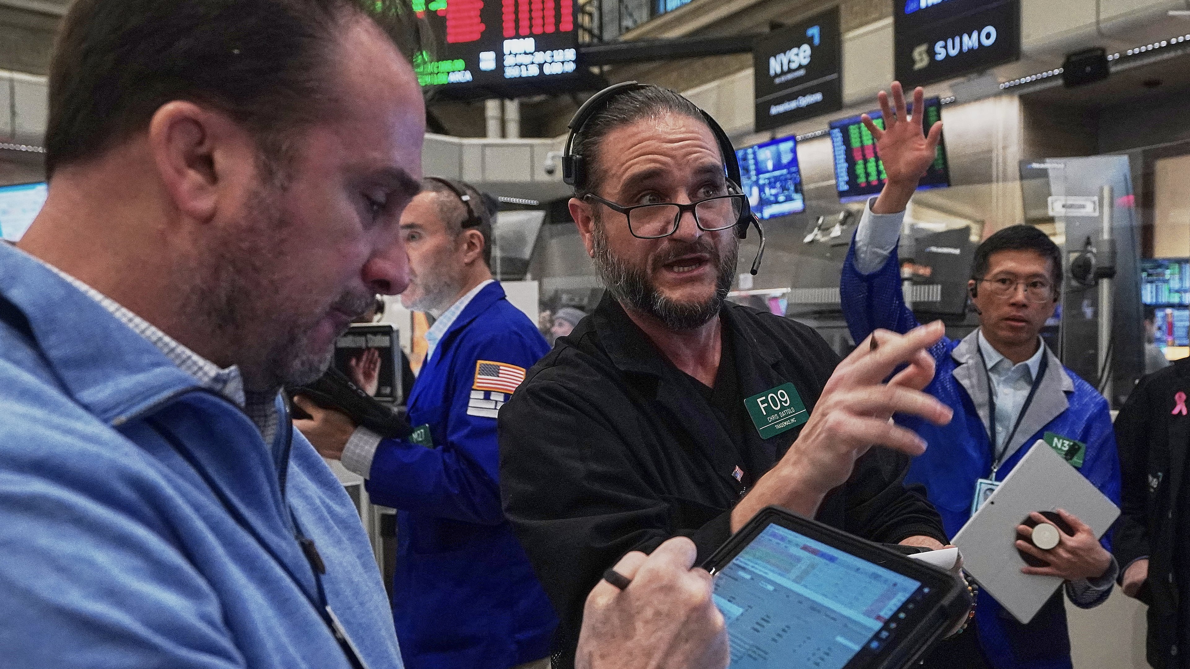 Chris Dattolo, center, works with fellow options traders on the floor of the New York Stock Exchange, Thursday, Jan. 22, 2026. (AP Photo/Richard Drew)