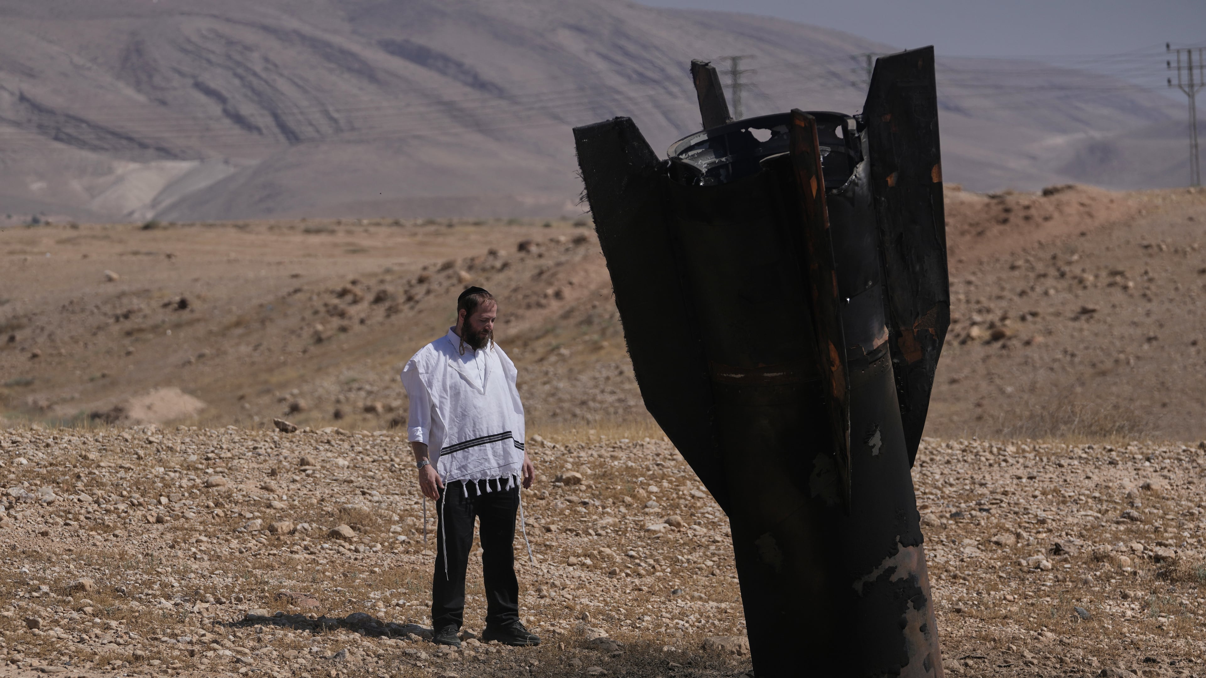 A man look at the wreckage of an Iranian missile that landed near the West Bank city of Jericho Monday, June 8, 2026. (AP Photo/Mahmoud Illean)