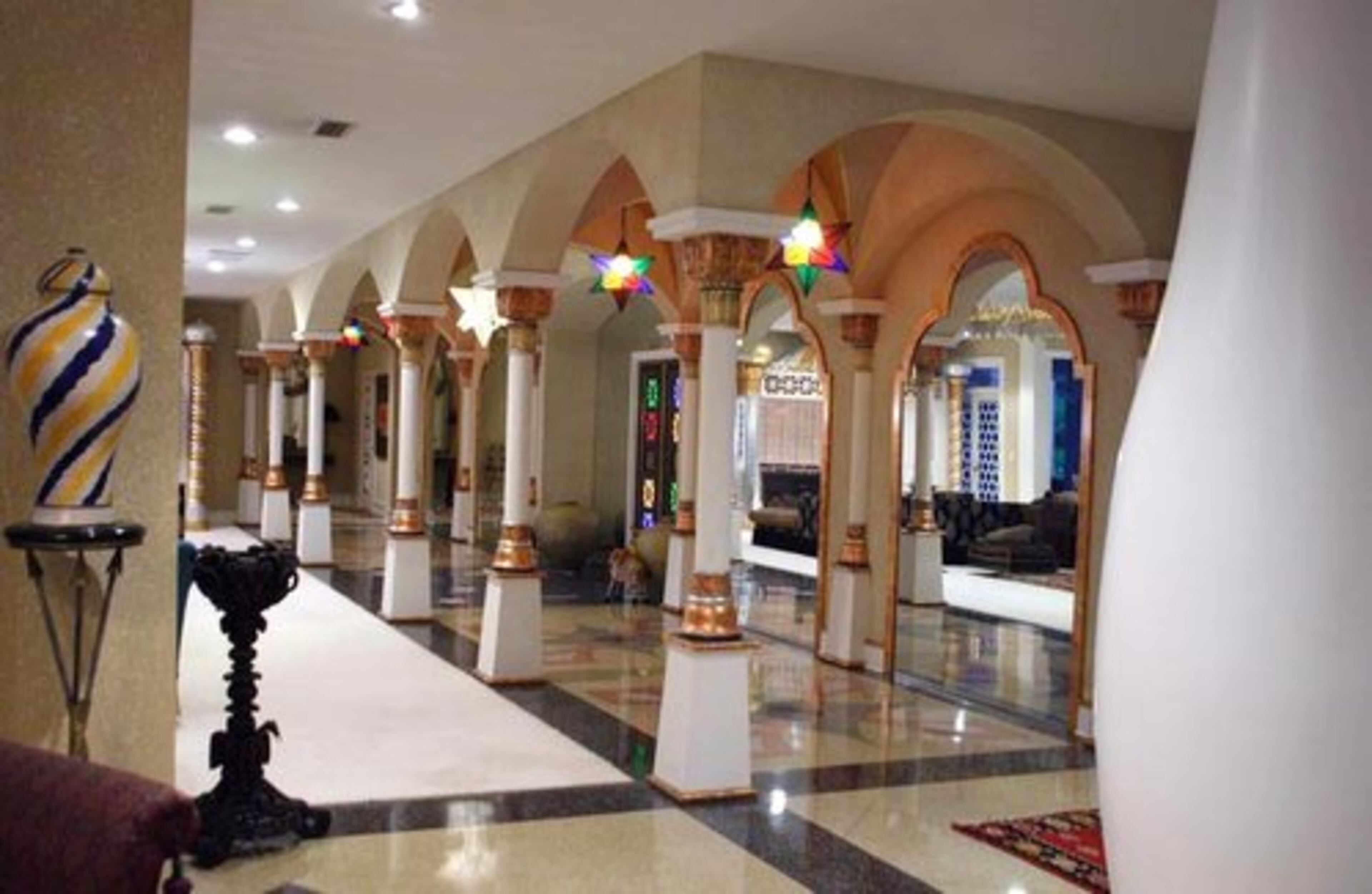 On the terrace level of the Dean Gardens estate, a lavishly decorated hallway with grand arches leads guests to the media rooms of the mansion, featuring the latest in audio and video technology. The columns are reproductions of those found at the Fox Theatre.