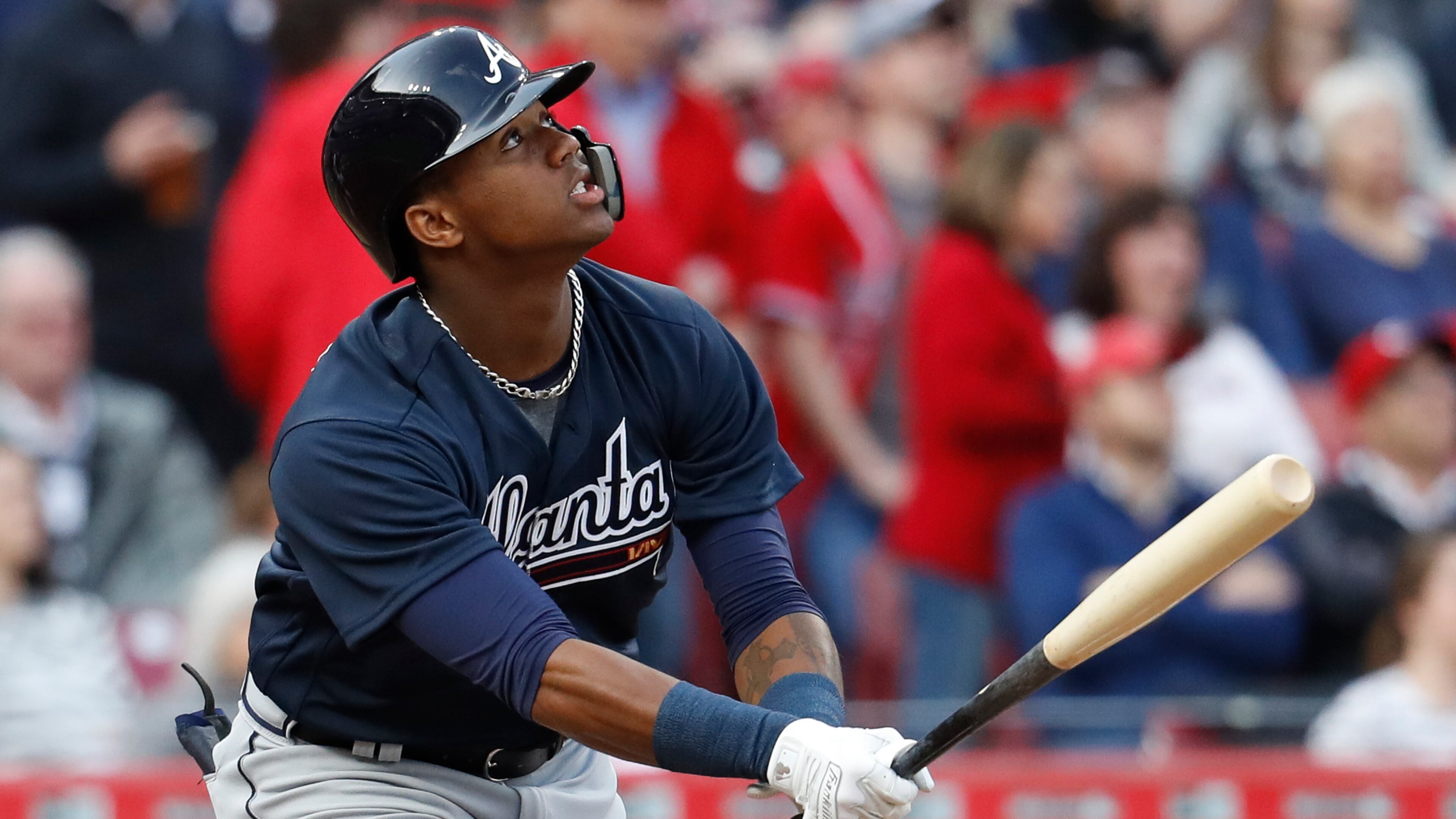 Atlanta Braves' Ronald Acuna Jr. flies out against Cincinnati Reds starting pitcher Brandon Finnegan during the first inning of a baseball game, his first at-bat in the majors, Wednesday, April 25, 2018, in Cincinnati. (AP Photo/John Minchillo)
