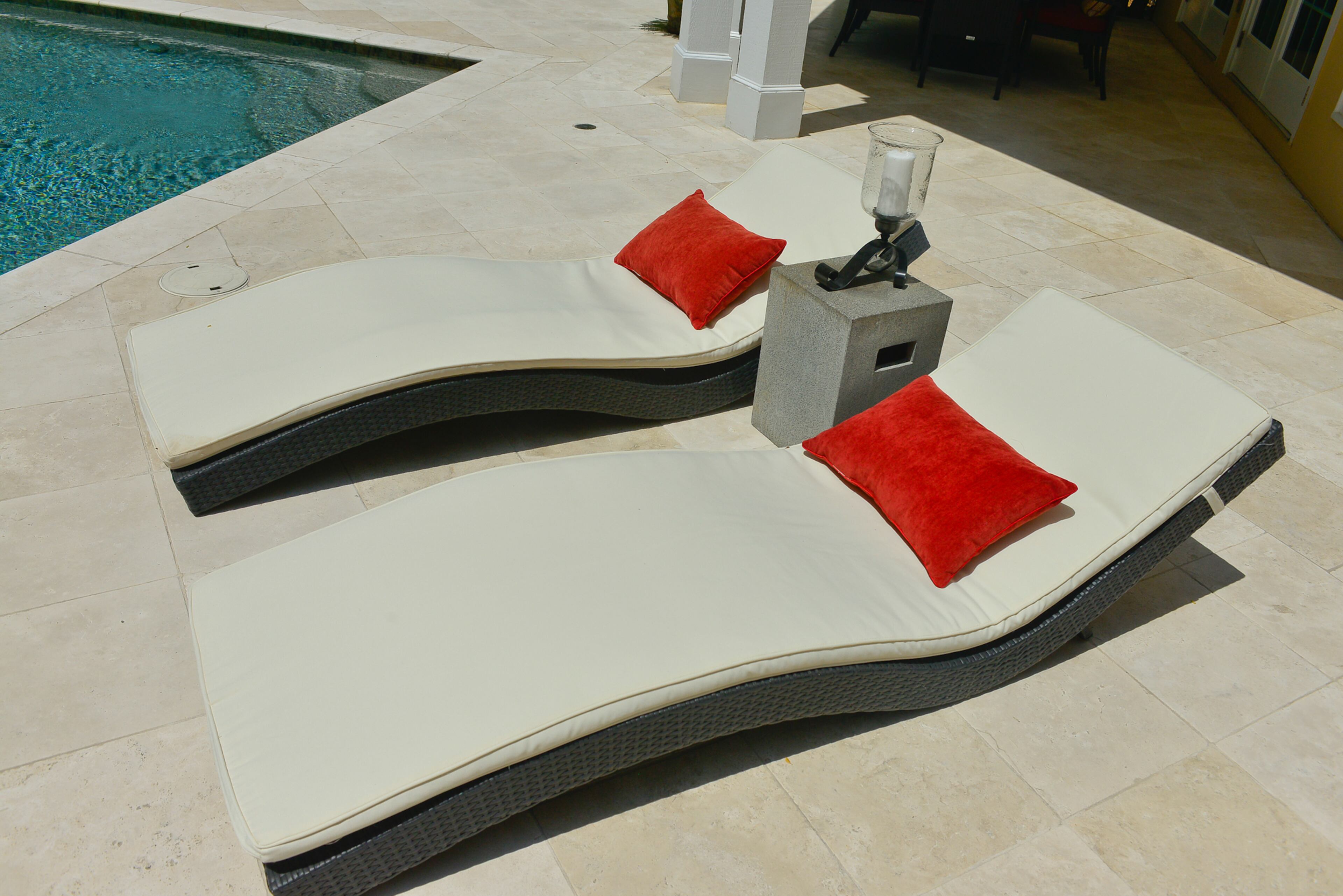 With the pool a focal point, homeowner Jeffrey Bulvin decided to splurge on high-end white tiles instead of concrete for the patio. The chaise lounges and side table are among the modern decor elements.