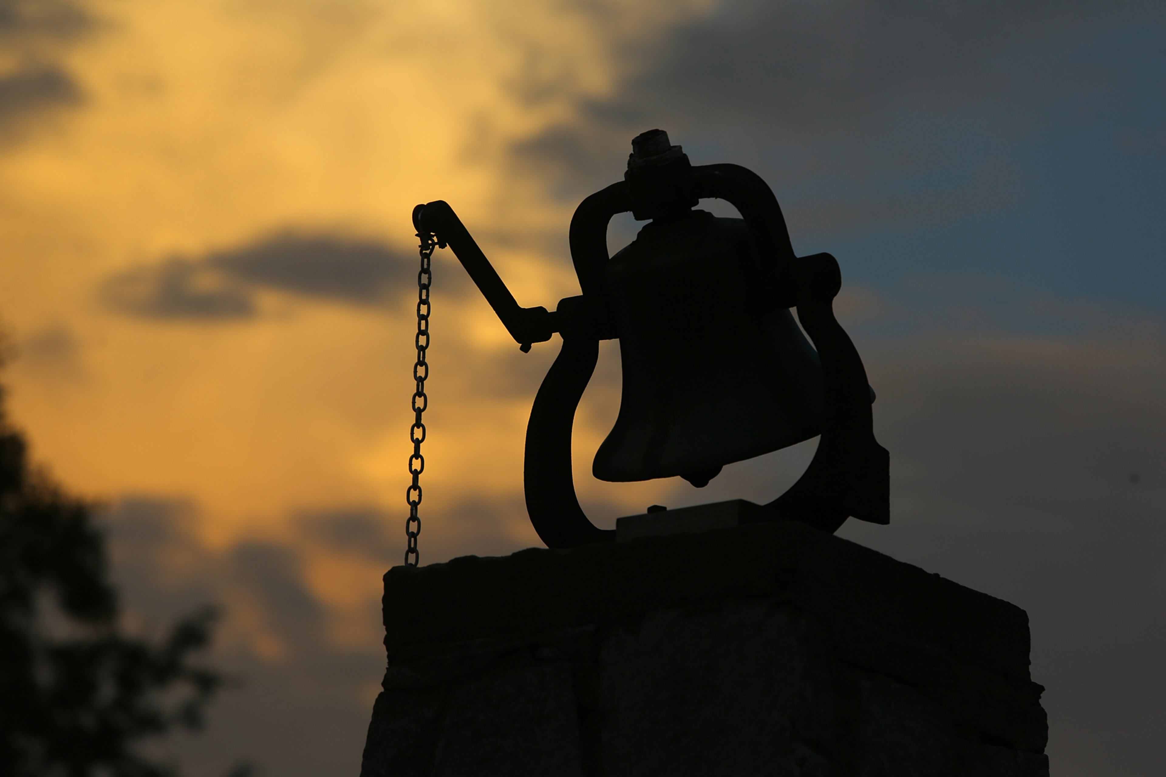 The light fades at the end of the day behind the old camp bell that has been ringing worshipers to the tabernacle since 1891 at the Smyrna Presbyterian Church camp meeting on Tuesday, June 24, 2014, in Conyers.