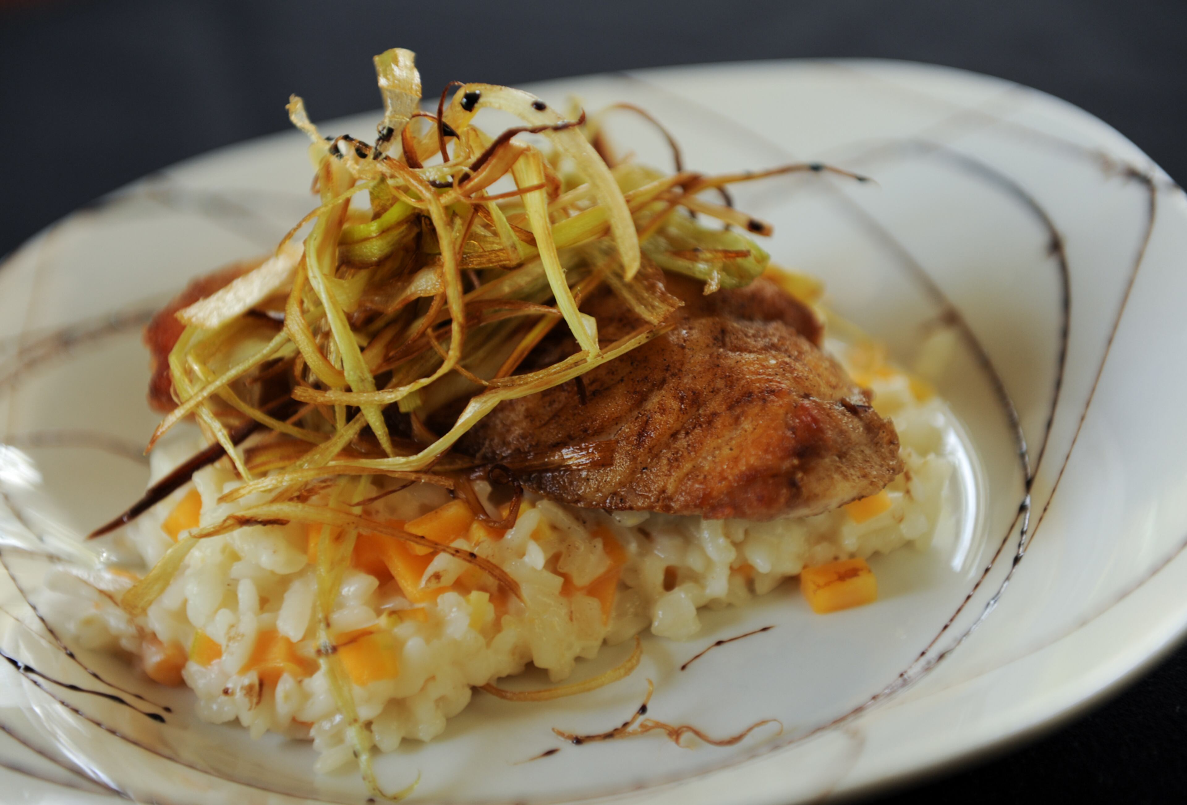 Local pan seared grouper, caramelized onion and butternut squash risotto, fried leek and balsamic reduction at Graft. (BECKY STEIN/special)