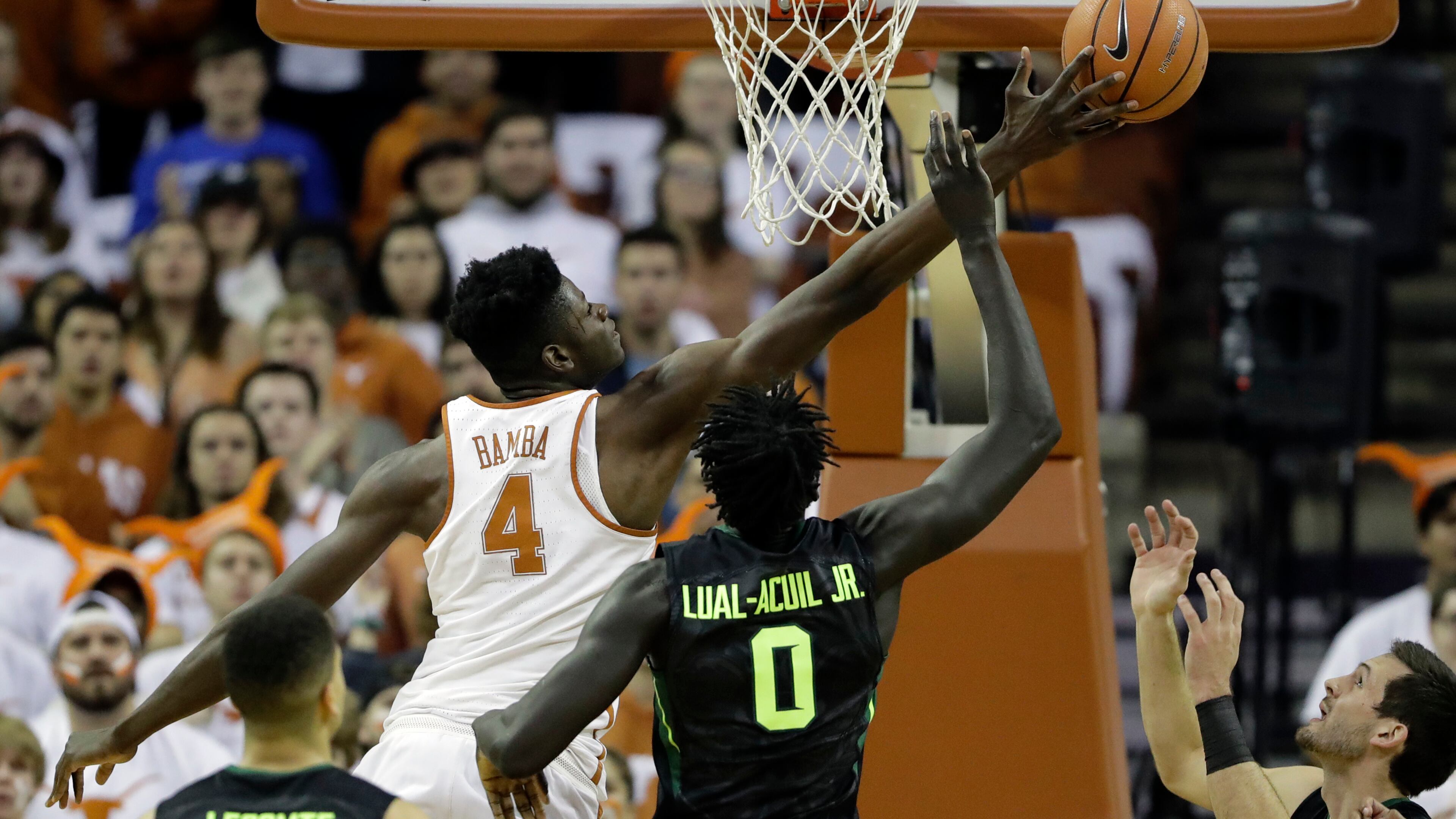 Texas forward Mohamed Bamba (4) and Baylor forward Jo Lual-Acuil Jr. (0) battle for a rebound during the first half of an NCAA college basketball game, Monday, Feb. 12, 2018, in Austin, Texas. (AP Photo/Eric Gay)