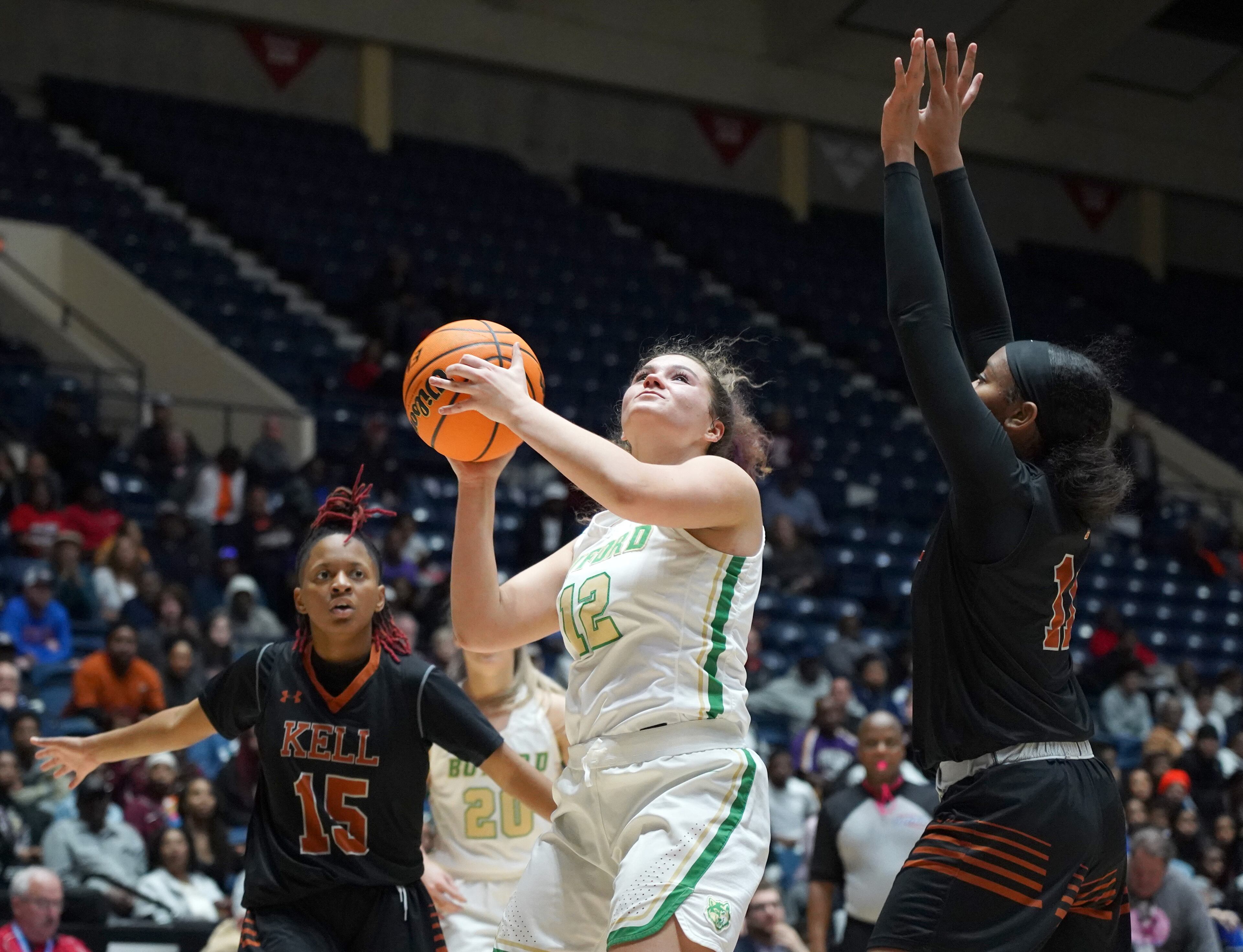 Buford's Kaitlyn Klein (12) drives between Kell's Makyah Favors (15) and Jada Green in the first half at the Class AAAA girls title basketball game at the Macon Centreplex, Friday March 6, 2020, in Macon. Tami Chappell for the Atlanta Journal Constitution