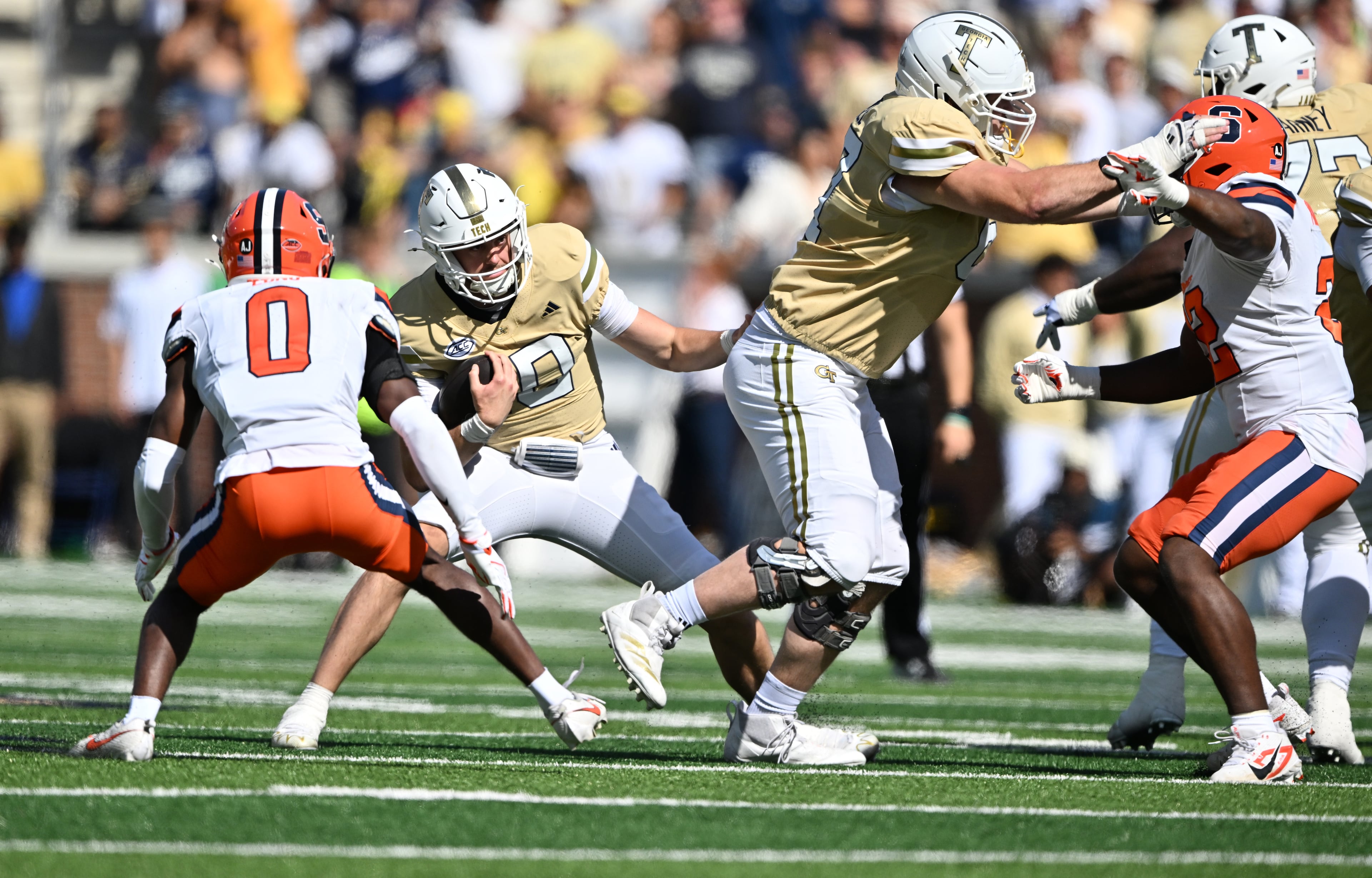 Georgia Tech quarterback Haynes King (second from left) runs the ball against Syracuse defensive back Braheem Long Jr. (0) during the first half of an NCAA college football game at Bobby Dodd Stadium, Saturday, Oct. 25, 2025 in Atlanta. (Hyosub Shin/AJC)
