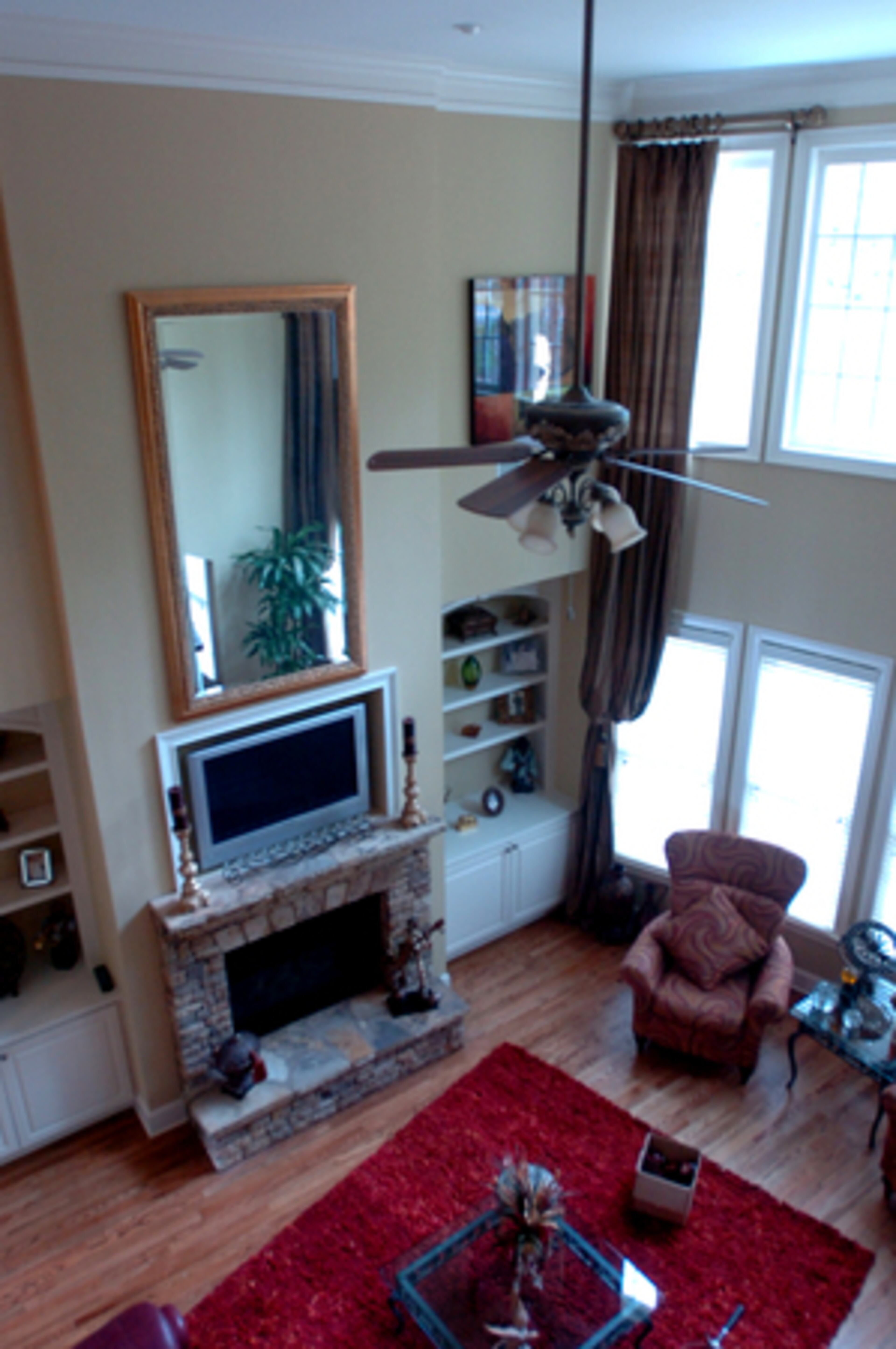 The family room has 18 foot ceilings, a stone fireplace and a wall of oversized windows.