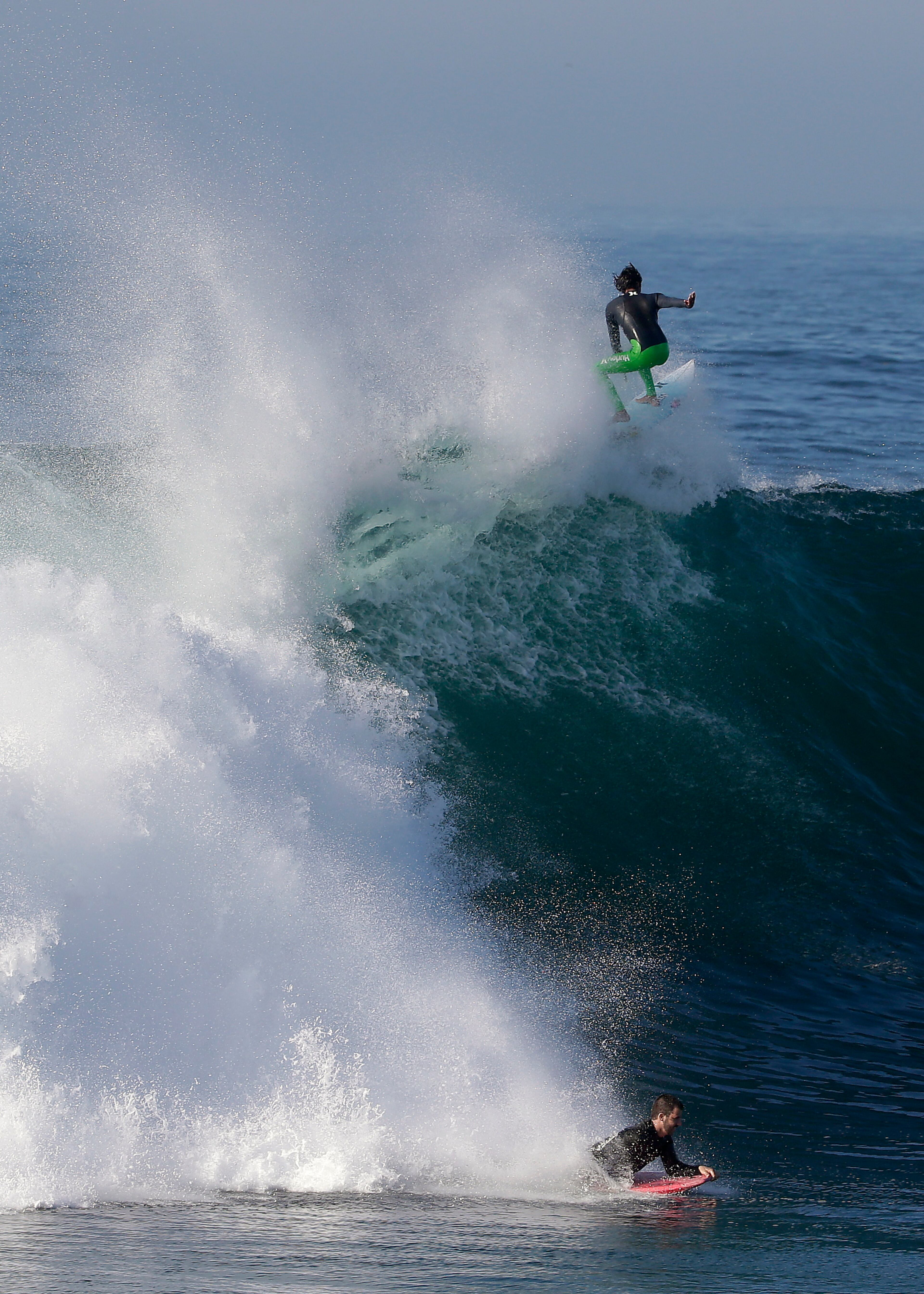 A bogieboarder and a surfer ride a wave at the wedge in Newport Beach, Calif., Wednesday, Aug. 27, 2014. Southern California beachgoers experienced much higher than normal surf, brought on by Hurricane Marie spinning off the coast of Mexico. (AP Photo/Chris Carlson)