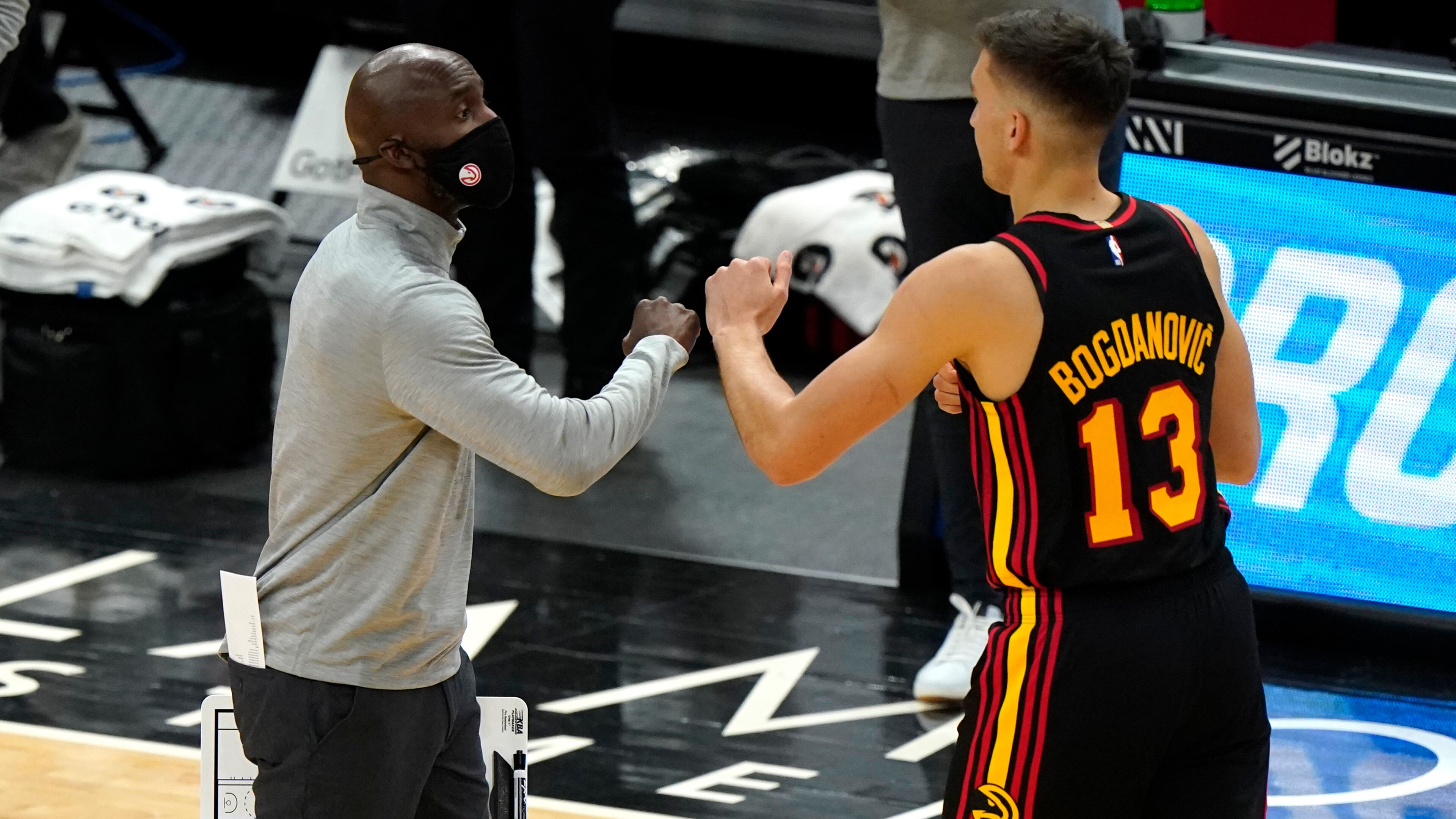 Hawks coach Lloyd Pierce celebrates with guard Bogdan Bogdanovic during the first half of Wednesday's Hawks-Bulls game in Chicago.