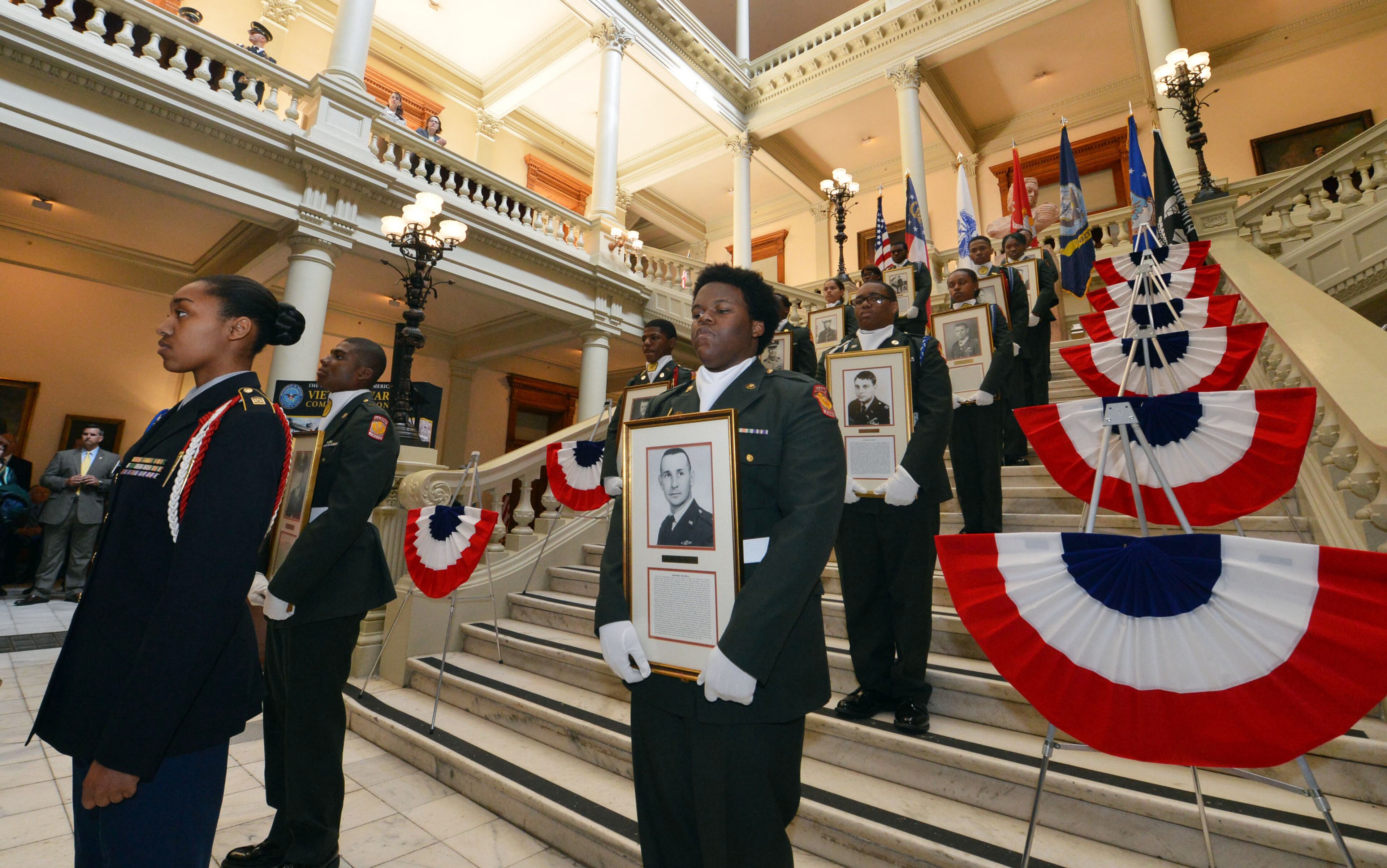 Members of the Westlake HS Army JROTC program present portraits of the Medal of Honor recipients during the program. Veterans, family members and state officials attend a ceremony honoring Medal of Honor recipients from the Vietnam War at the Georgia Capitol Tuesday, March 25, 2014. Twelve Georgians, veterans of the Vietnam War, possess the Medal of Honor. It is the highest accolade this nation gives its warriors. On Tuesday, they were recognized in a special ceremony at the Capitol. Gov. Nathan Deal proclaimed March 29 as Vietnam Veterans Day in Georgia. KENT D. JOHNSON / KDJOHNSON@AJC.COM