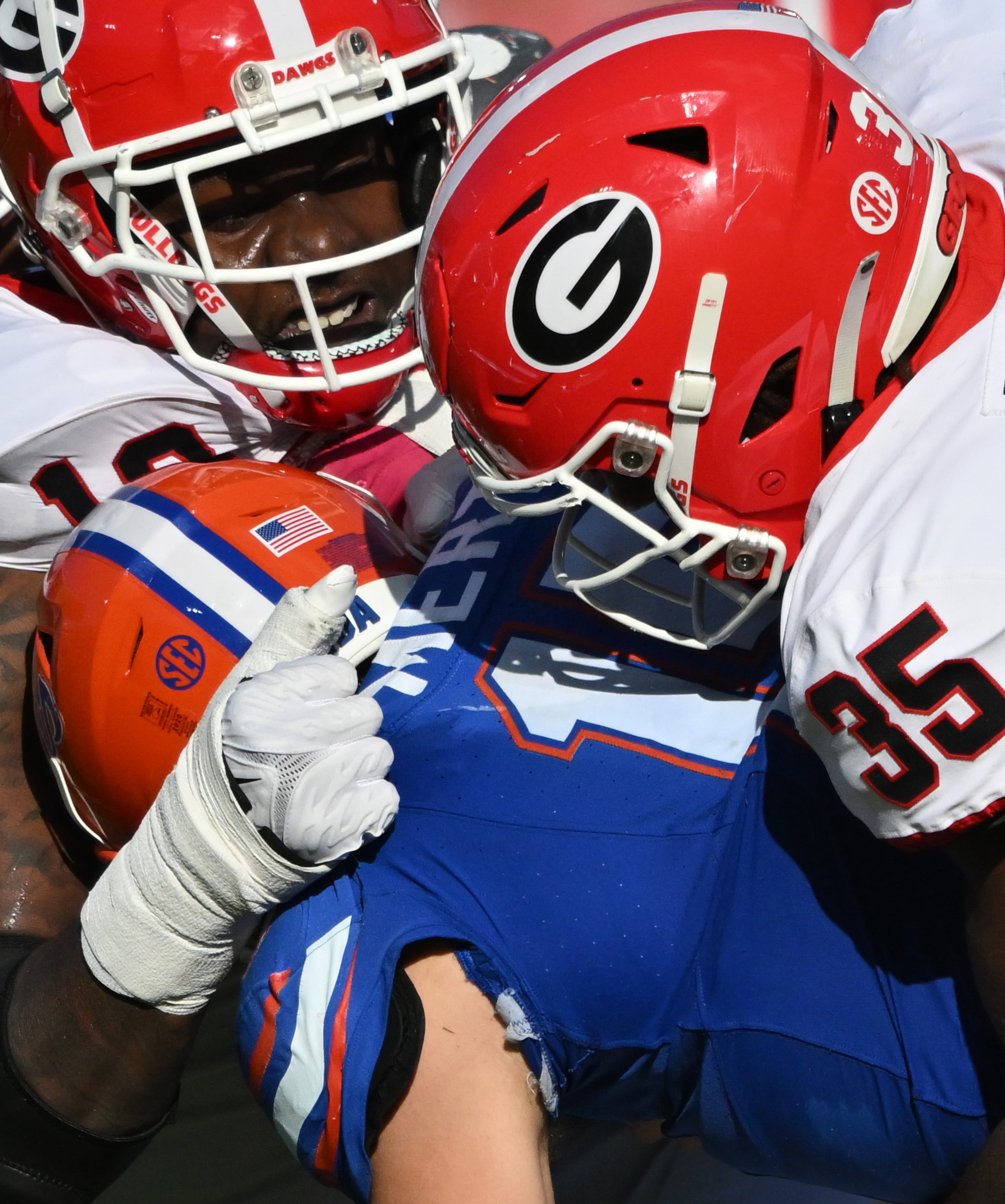 Florida quarterback Graham Mertz (15) is sacked by Georgia defensive lineman Mykel Williams (13) and Georgia linebacker Damon Wilson Jr. (35) during the second half in an NCAA football game at EverBank Stadium, Saturday, October 28, 2023, in Jacksonville, FL. Georgia won 43-20 over Florida. (Hyosub Shin / Hyosub.Shin@ajc.com)