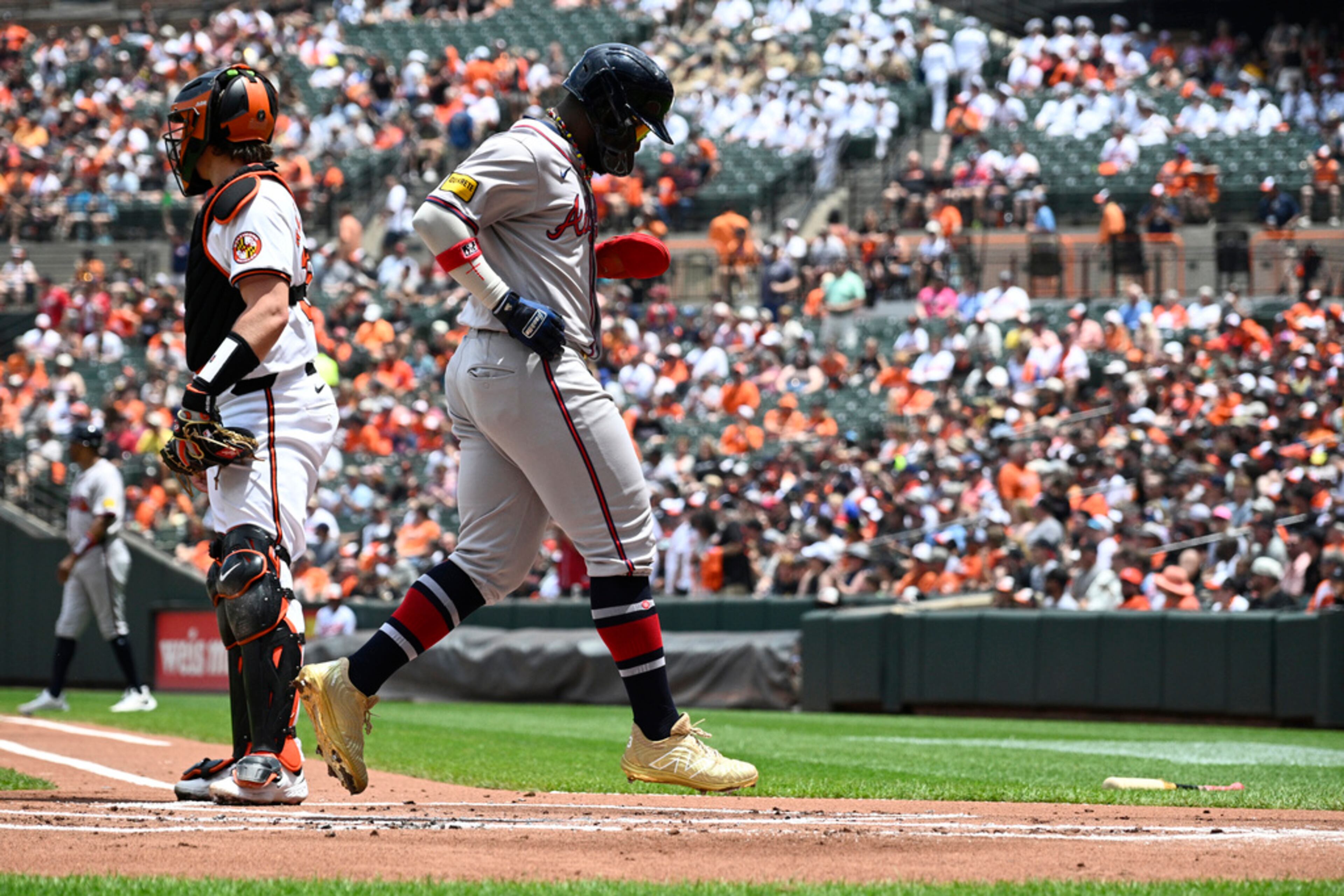 Atlanta Braves' Michael Harris II, right, comes home to score past Baltimore Orioles catcher Adley Rutschman, left, on a double by Marcell Ozuna during the first inning of a baseball game, Thursday, June 13, 2024, in Baltimore. (AP Photo/Nick Wass)