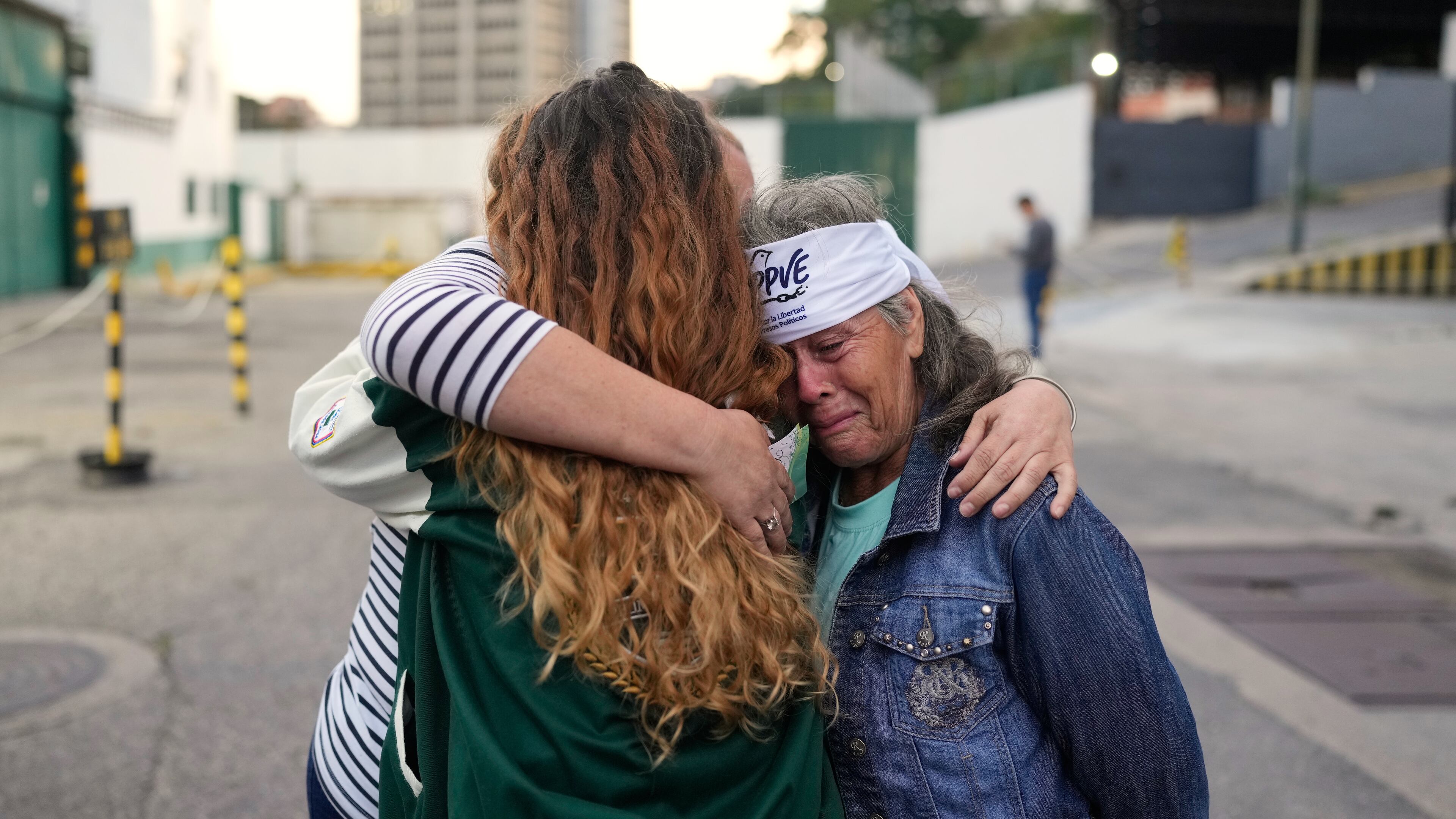 Flor Zambrano, whose son, Rene Chourio, she says is detained at Zone 7 of the Bolivarian National Police for political reasons, embraces relatives of other detainees outside the facility in Caracas, Venezuela, Monday, Jan. 12, 2026. (AP Photo/Matias Delacroix)