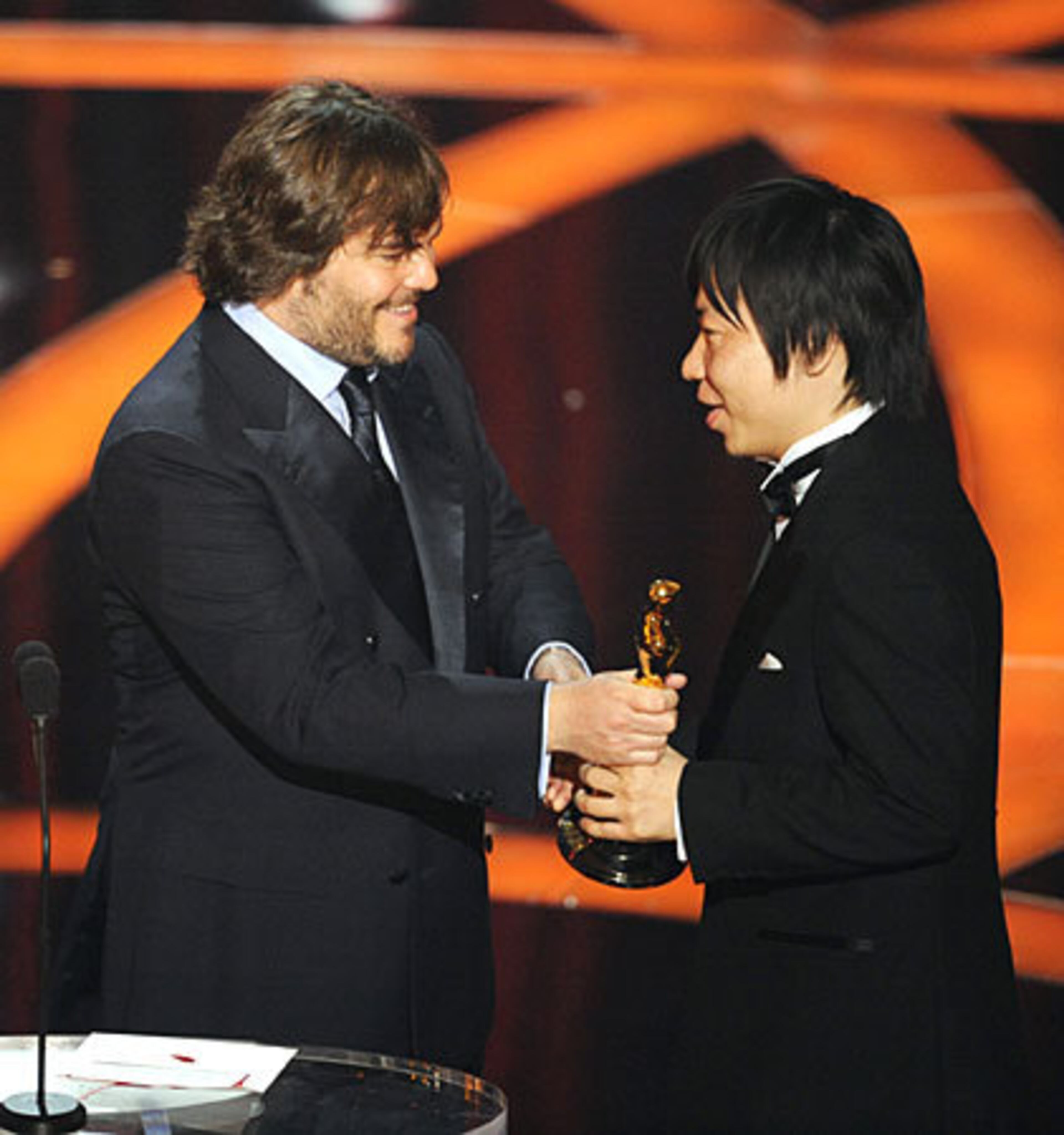 Kunio Kato, right, accepts the Oscar for best animated short film for "La Maison En Petits Cubes" from presenter Jack Black.