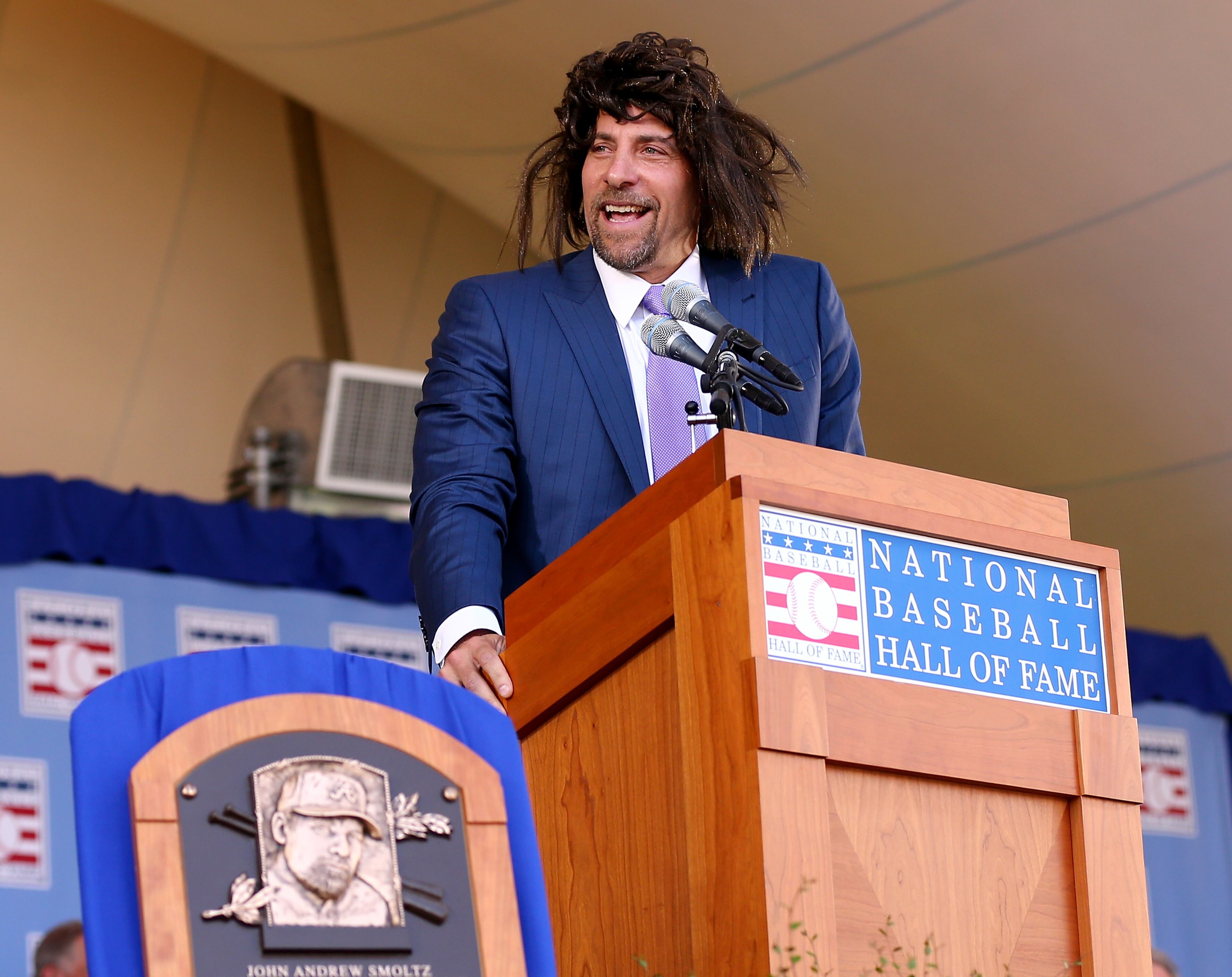 COOPERSTOWN, NY - JULY 26: John Smoltz tries to relive his early days with hair as he speaks wearing a wig during the Hall of Fame Induction Ceremony at National Baseball Hall of Fame on July 26, 2015 in Cooperstown, New York.Johnson was inducted with Pedro Martinez,Craig Biggio and John Smoltz (Photo by Elsa/Getty Images)