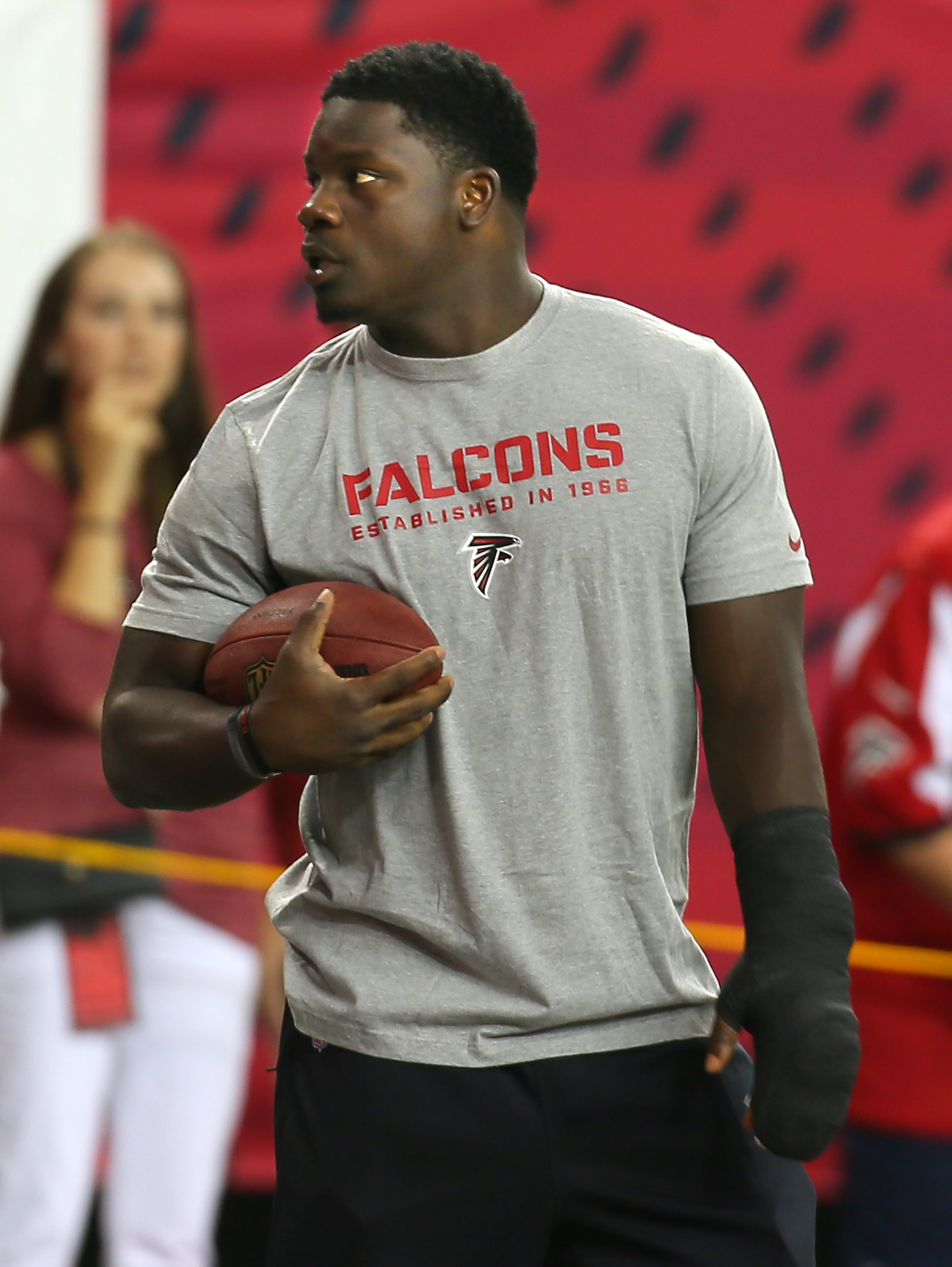 His hand and wrist wrapped, Falcons linebacker Sean Weatherspoon, who was not playing in the exhibition game, watches his teammates warm up.