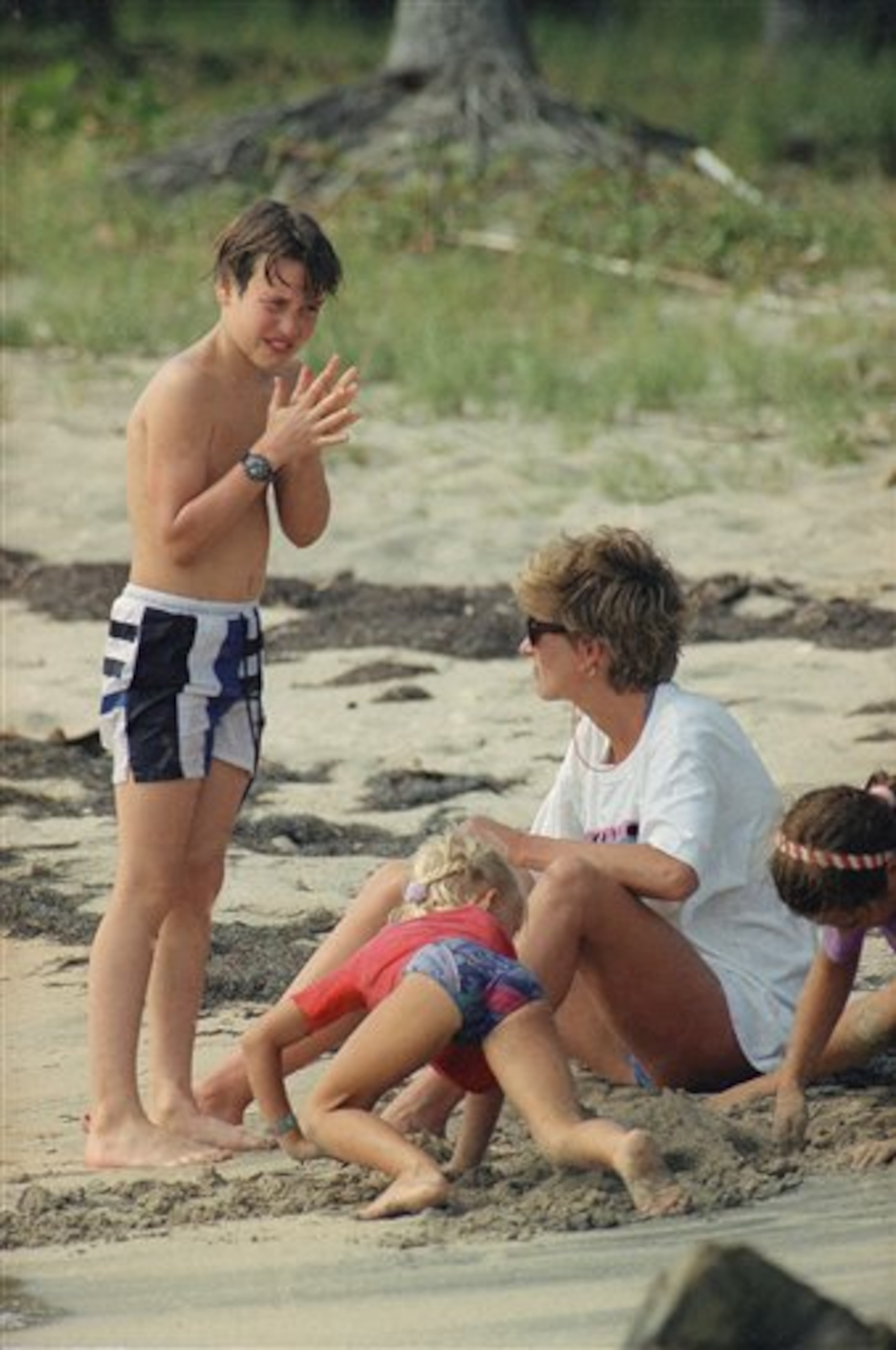 Prince William, son of Princess Diana, reacts as his mom adjusts the strap of his diving mask on Banana Bay Beach in St. Kitts, West Indies on Monday, Jan. 4, 1993. They are vacationing in the Caribbean. (AP Photo/Richard Drew)