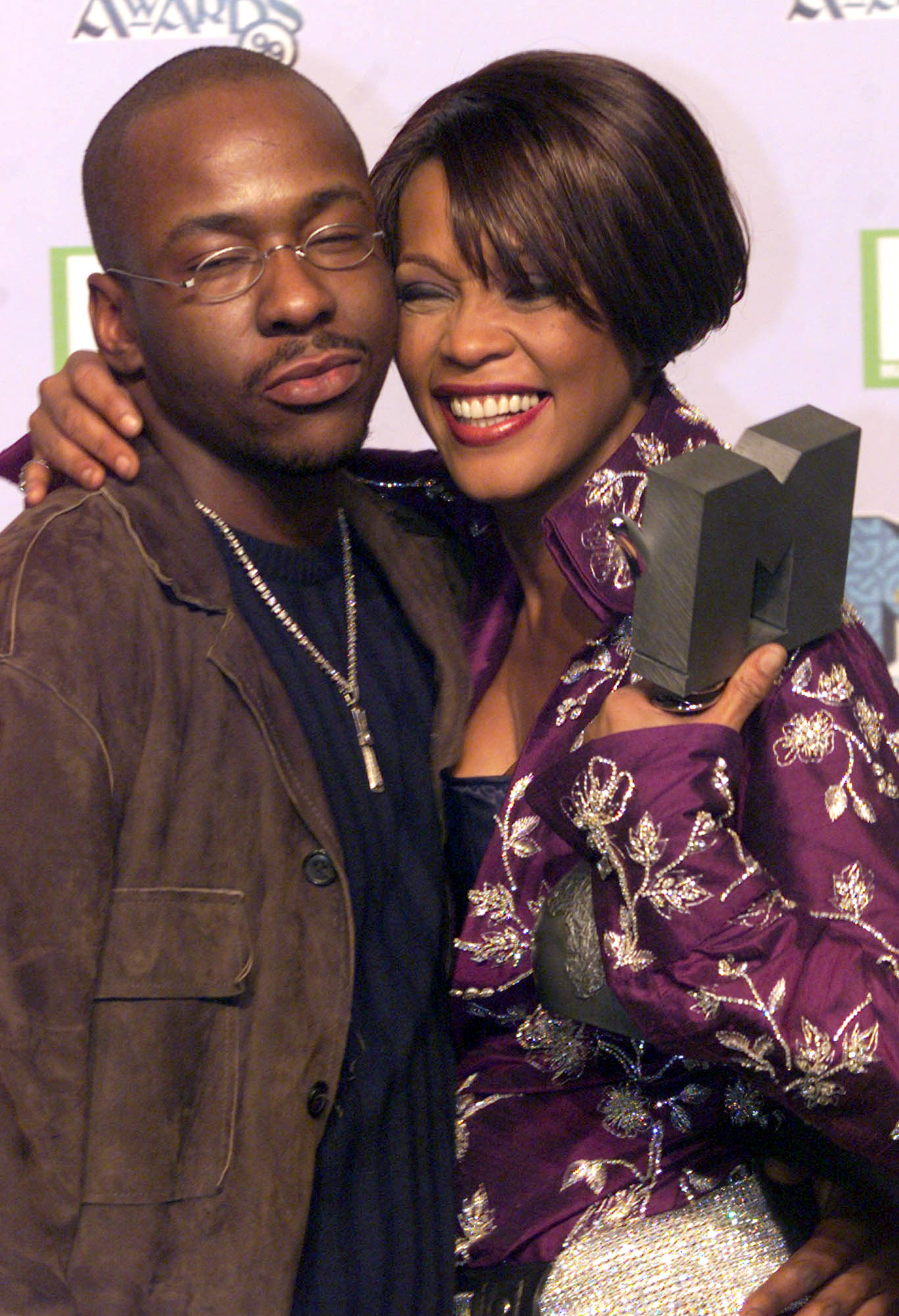 Singer Whitney Houston, holding her MTV Music award, poses with husband Bobby Brown for photographers at a photocall after winning the Best R & B category Thursday Nov.11, 1999. The MTV Europe Music Awards, voted for by MTV viewers and Europe's biggest awards, were held at The Point, Dublin. (AP Photo/Christine Nesbitt)