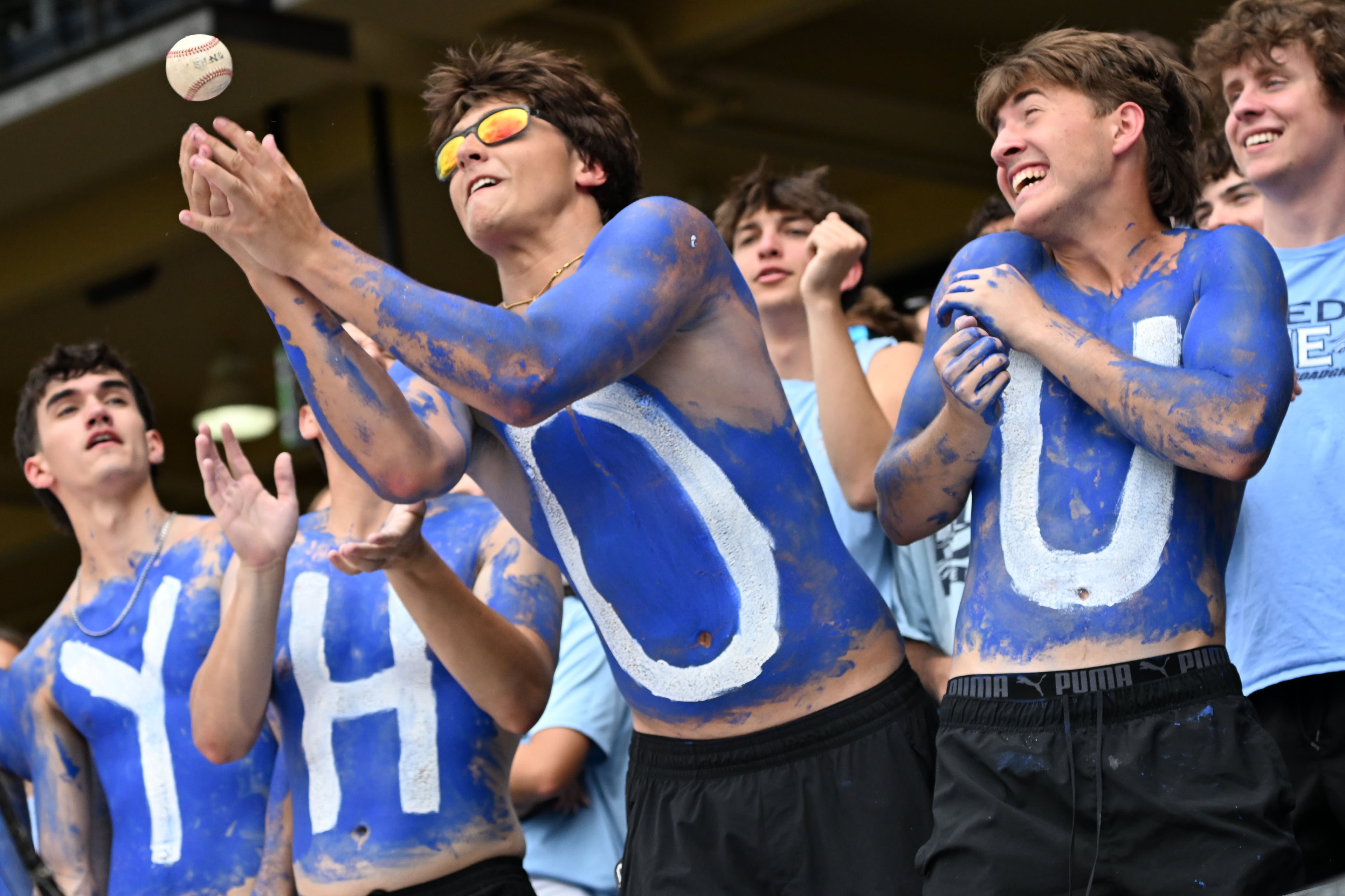 A Pope fan tries to catch a foul ball during the fifth inning of Game 1 of the GHSA Class 5A baseball state championship series Monday, May 25, 2026, at Gwinnett Field in Lawrenceville. (Hyosub Shin/AJC)