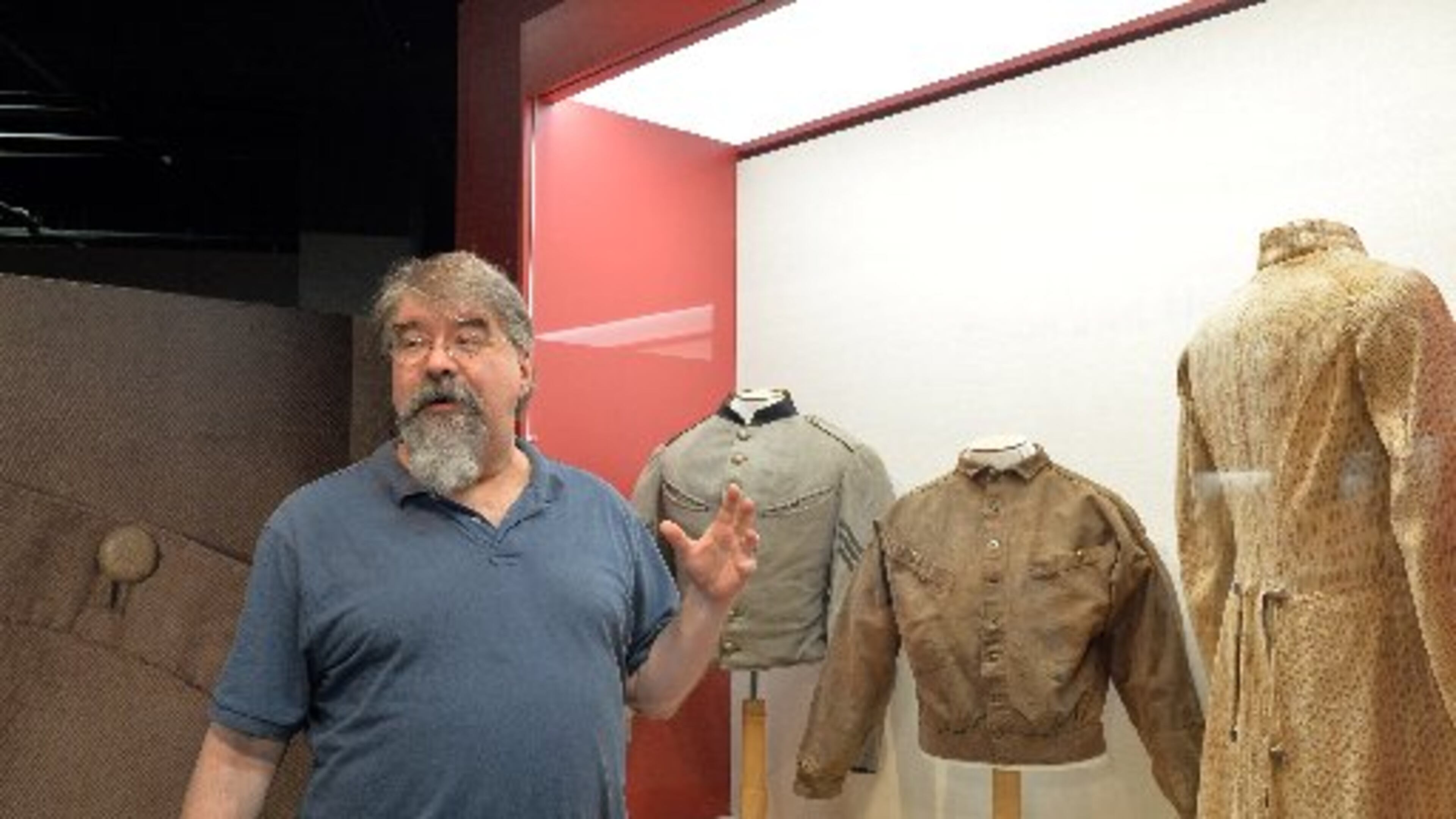 Gordon Jones, Atlanta History Center senior military historian and curator, in shown in the exhibit "Confederate Odyssey: The George W. Wray Collection." Far right: frock coat worn by 17-year-old Pvt. Benjamin Schumpert of the 3rd South Carolina Infantry when, in September 1863 during the Battle of Chickamauga, he was struck in the head by a minié ball and killed. KENT JOHNSON/ KDJOHNSON@AJC.COM