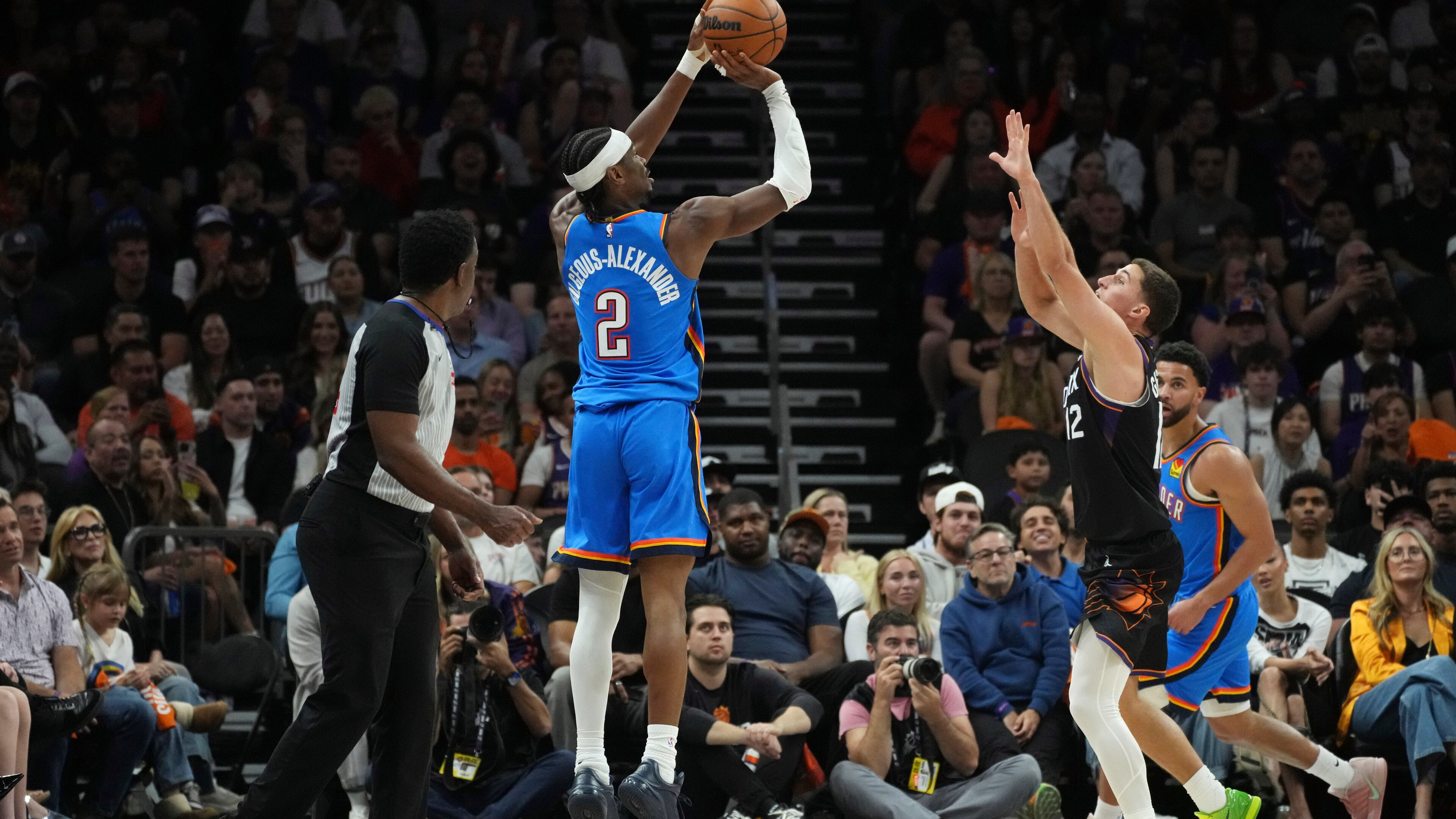 Oklahoma City Thunder guard Shai Gilgeous-Alexander (2) shoot a 3-pointer against Phoenix Suns guard Collin Gillespie (12) during the first half of Game 4 in a first-round NBA playoffs basketball series, Monday, April 27, 2026, in Phoenix. (AP Photo/Ross D. Franklin)