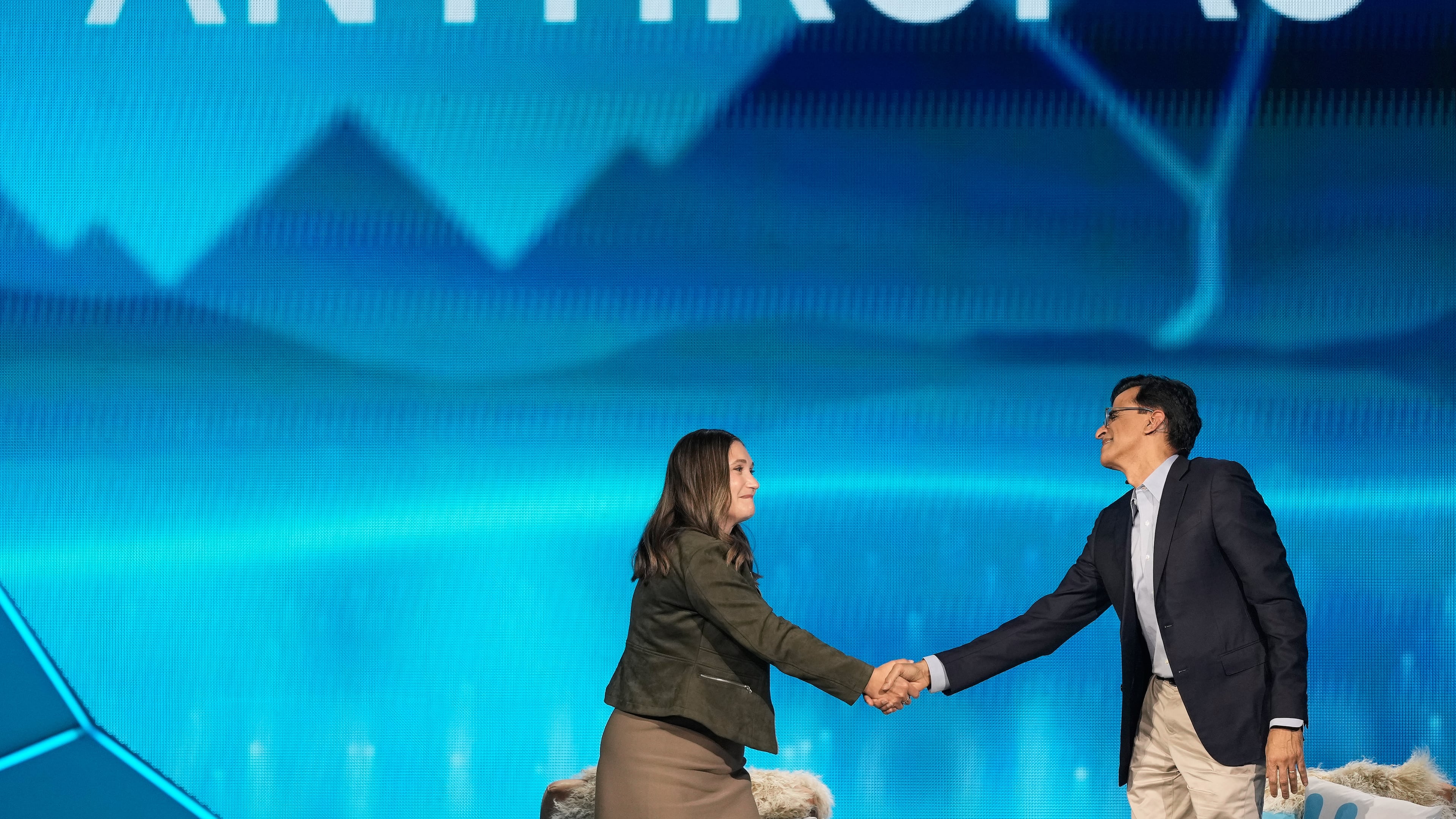 Anthropic co-founder and President Daniela Amodei, left, shakes hands with Snowflake CEO Sridhar Ramaswamy during the keynote presentaton at Snowflake Summit 26 Monday, June 1, 2026, in San Francisco. (AP Photo/Jeff Chiu)