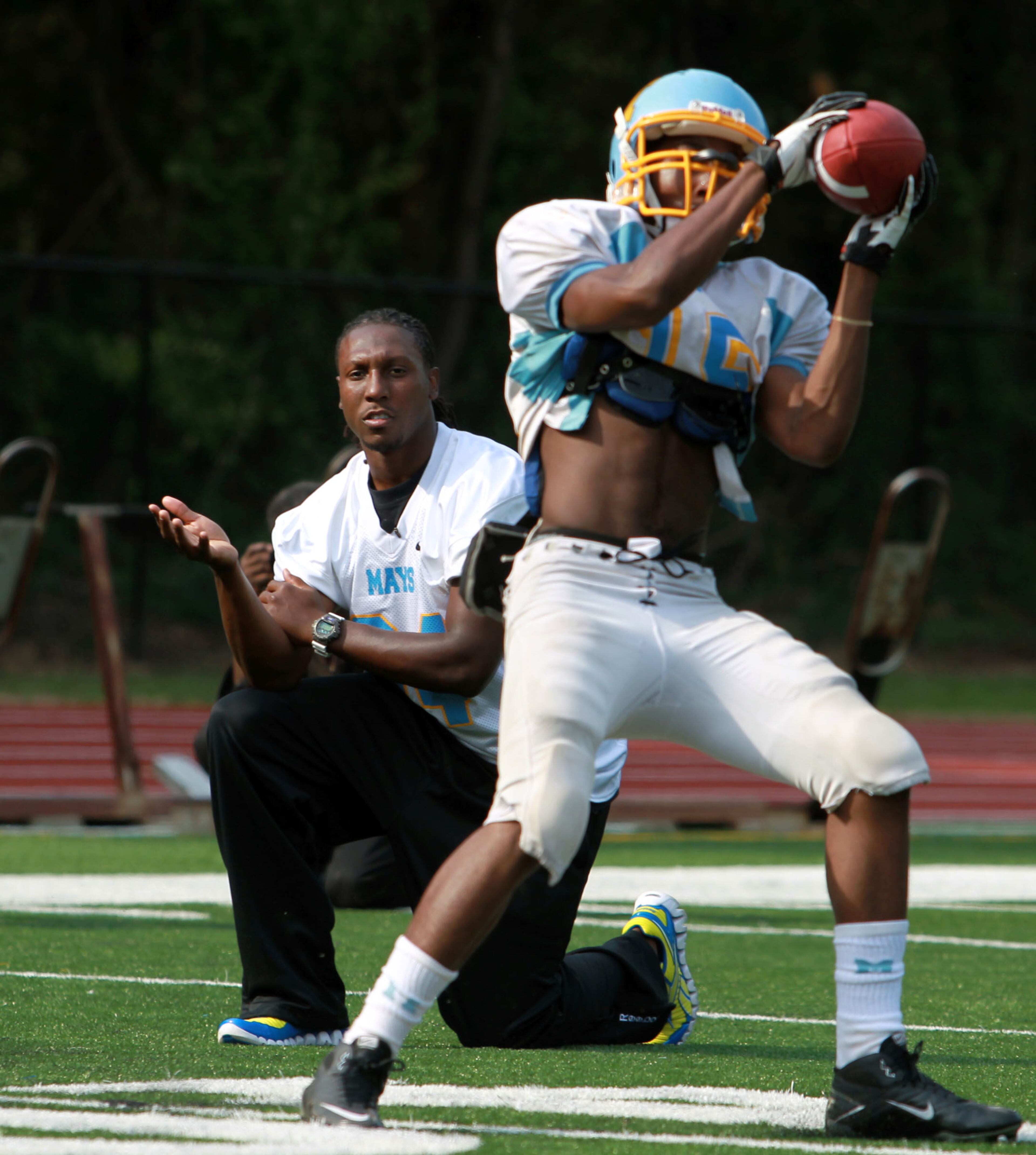 Atlanta Falcons wide receiver Roddy White, left, coaches wide receivers during football practice at Benjamin E. Mays High School Tuesday afternoon in Atlanta, Ga., September 25, 2012. White visited Mays high school and participated and interacted with students in lunch, math class, cheerleader practice, marching band practice, and football practice. Sponsored by Duracell, White helped donate items to Mays high school including football equipment and gear for the team, Texas Instruments calculators, Maglite flashlights, and a Zoll Automated External Defibrillator. JASON GETZ / JGETZ@AJC.COM