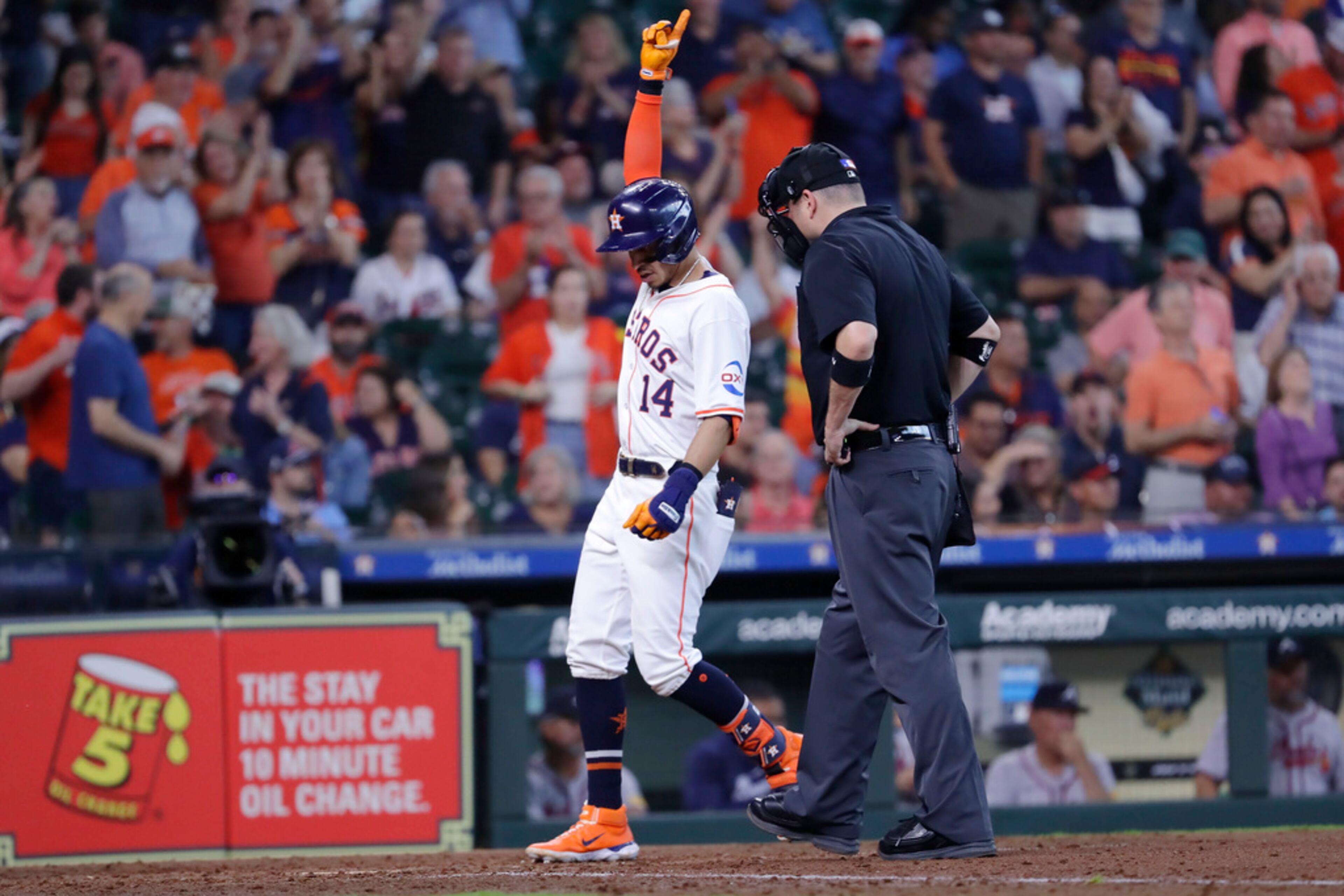 Houston Astros' Mauricio Dubon (14) celebrates his home run as he steps on home plate next umpire Dan Bellino, right, during the sixth inning of a baseball game against the Atlanta Braves Wednesday, April 17, 2024, in Houston. (AP Photo/Michael Wyke)