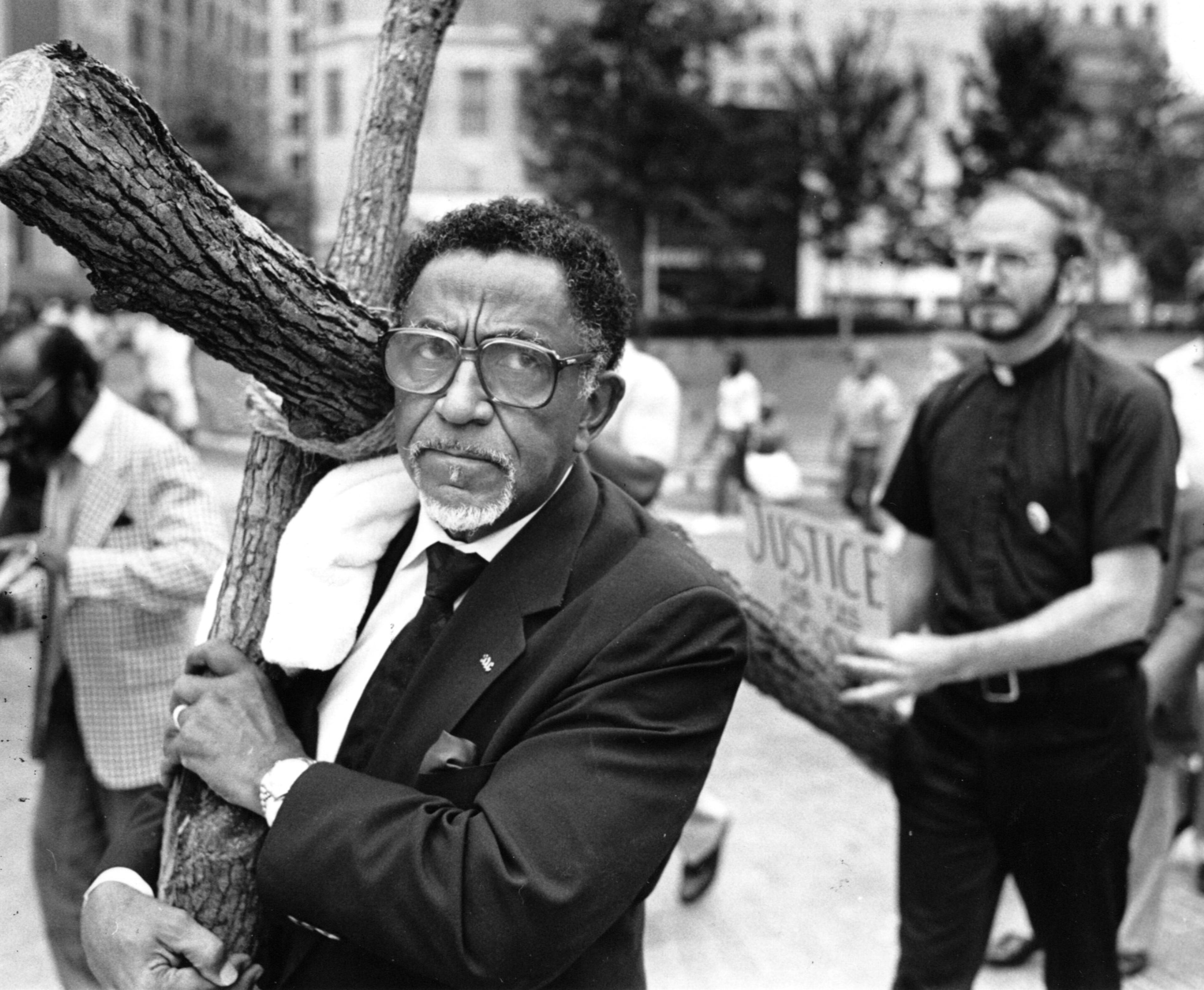 Rev. Joseph Lowery, president of the SCLC, carries a cross from Woodruff Park to the office of Attorney General Mike Bowers during a march against racism and the death penalty in 1987. (RICH ADDICKS/AJC staff)