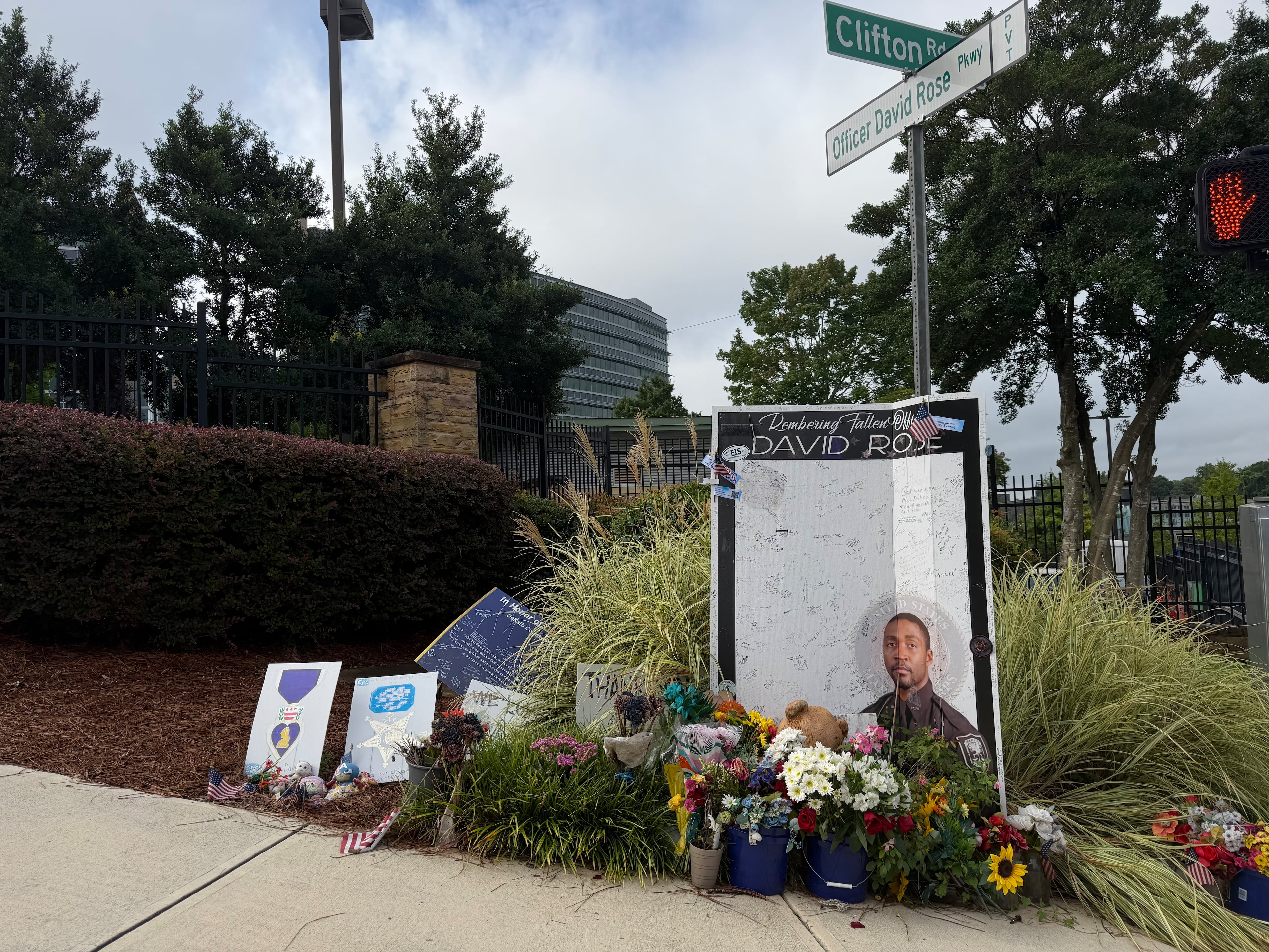 A sign displayed Friday, Aug. 7, 2026, outside the CDC in Atlanta memorializes Officer David Rose, killed in a shooting a year ago. (Sara Gregory/AJC)