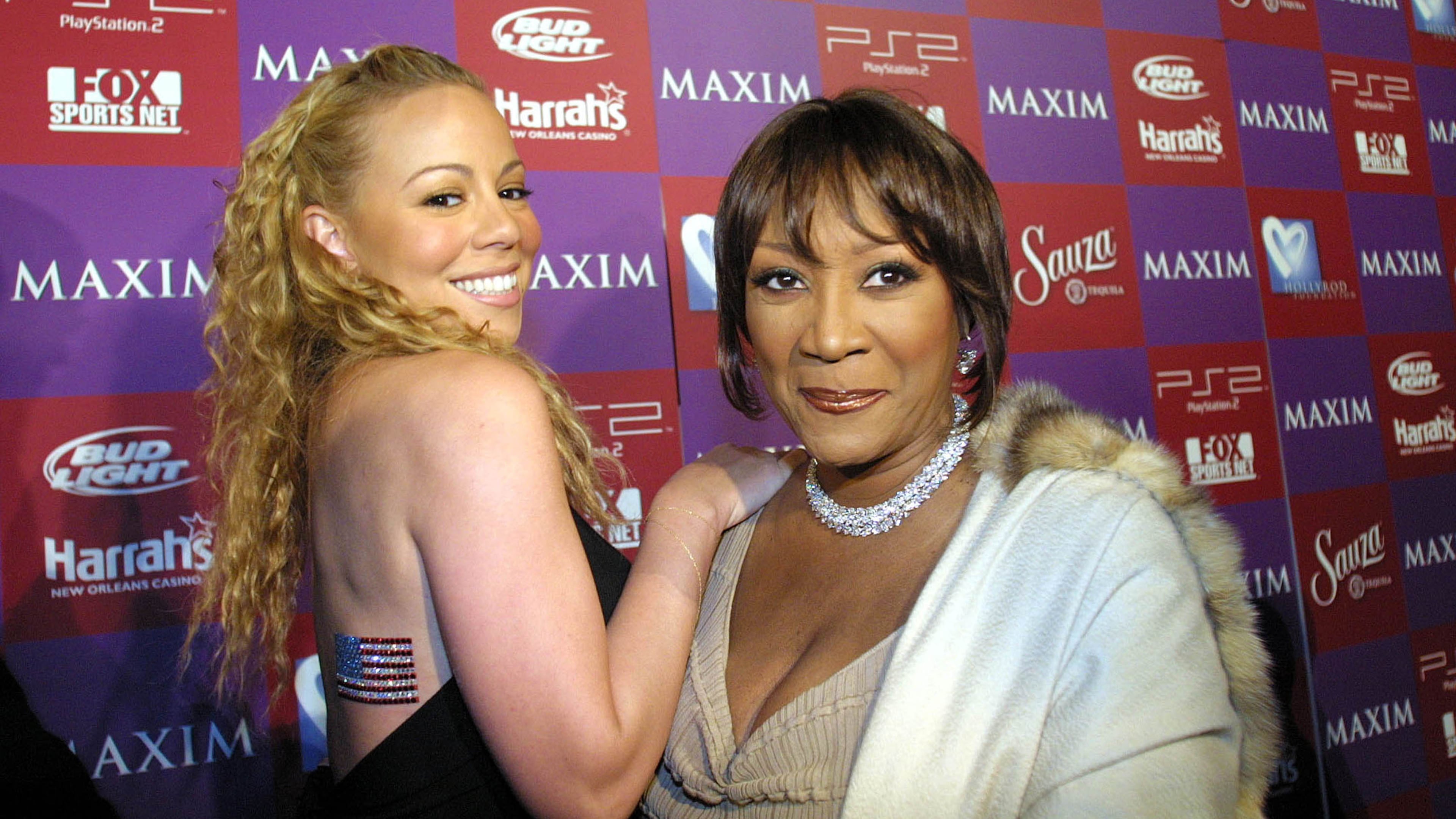 400387 01: Singer Mariah Carey shows off an American flag with singer Patti LaBelle at Maxims Super Bowl benefit for the HollyRod Foundation February 1, 2002 in New Orleans, LA. (Photo by Ronald Martinez/Getty Images)