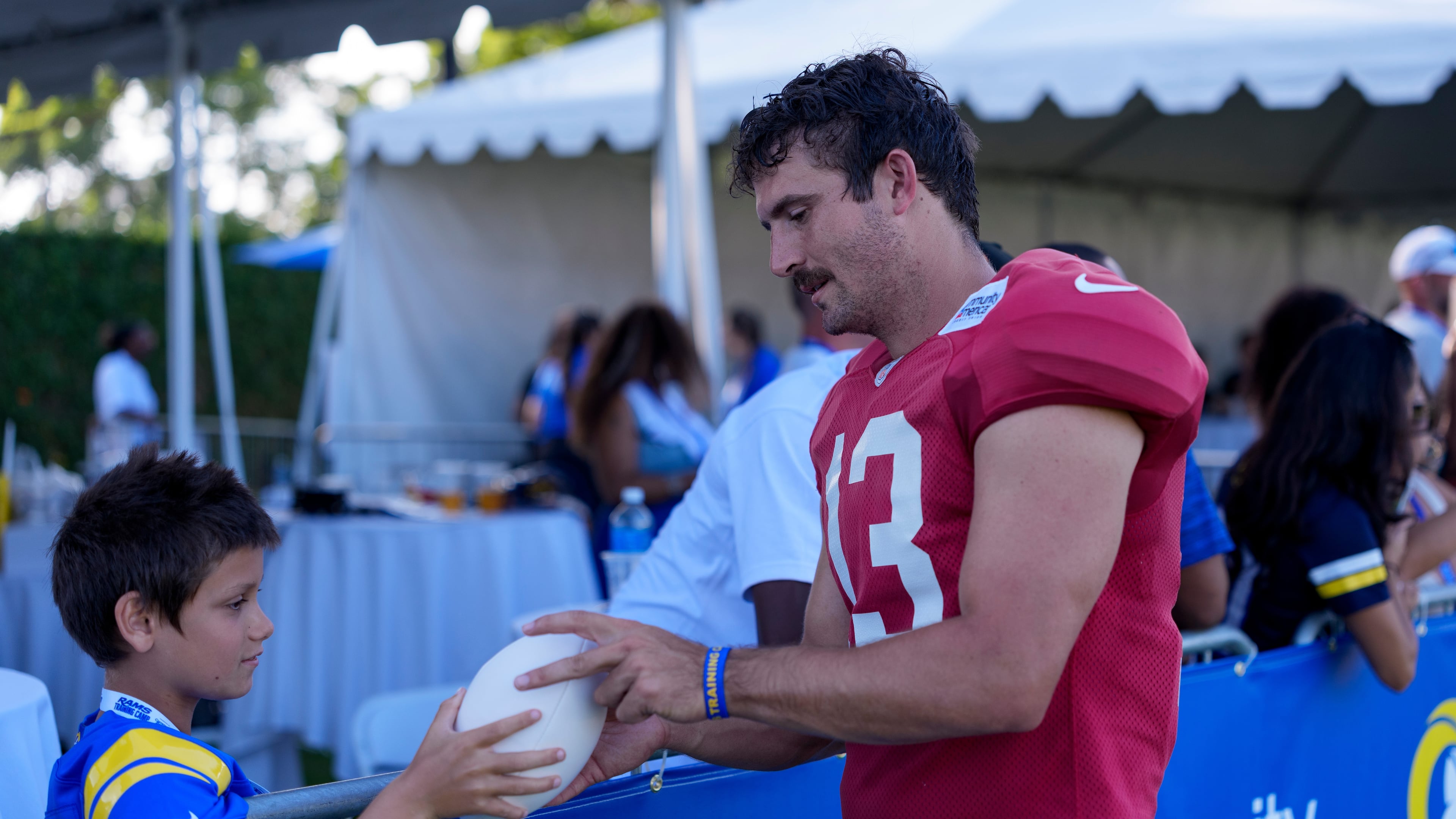 Los Angeles Rams quarterback Stetson Bennett IV (13) interacts with fans after training camp on Friday, July 31, 2026, in Los Angeles. (Miya Tanner via AP)