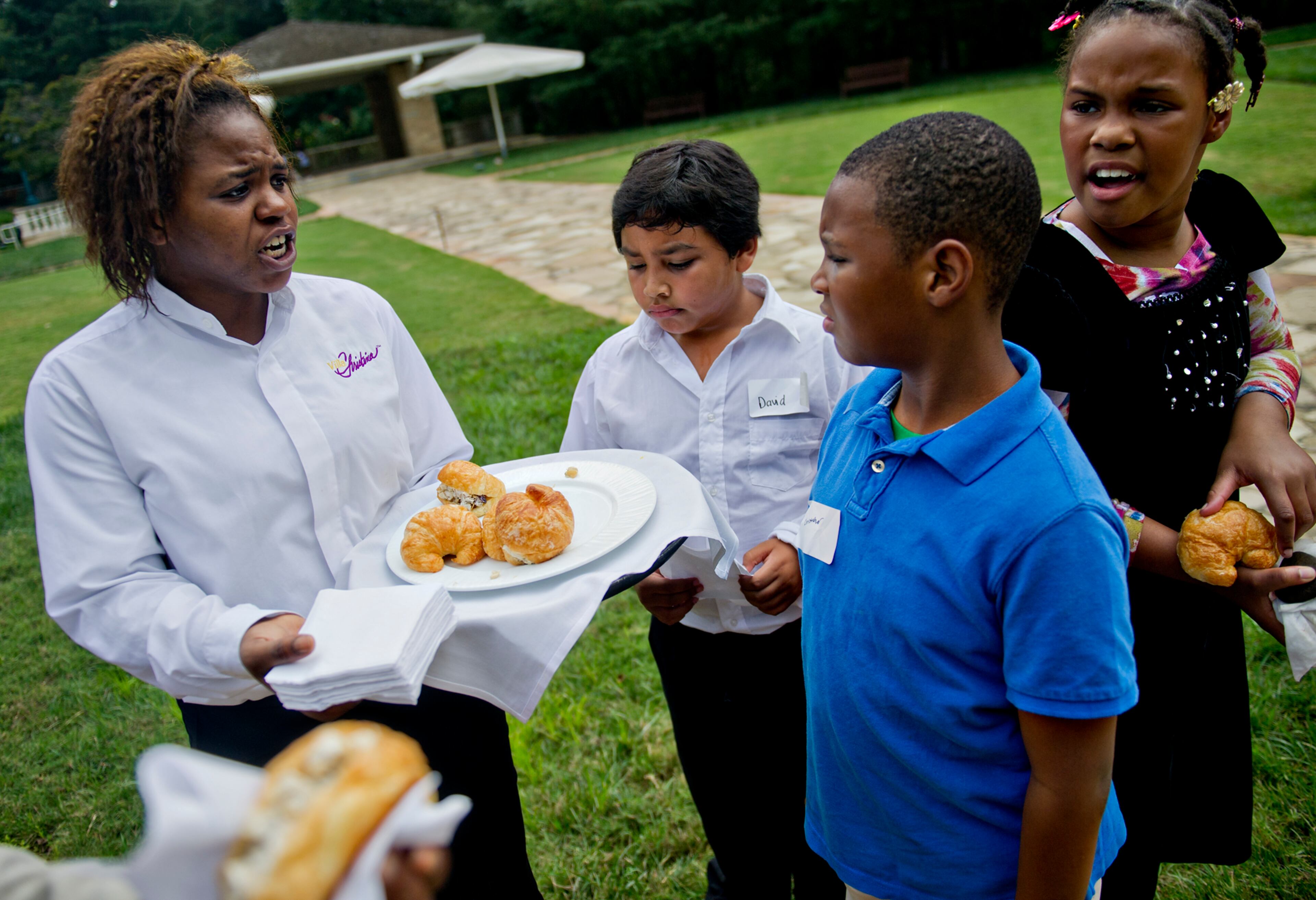 Shantell Fallen (left) serves chicken salad croissants to David Fili, Christopher Ellis and Ariell Taylor as they wait for the start of the Fowler Family Celebration of Love at Villa Christina in Atlanta on Sunday, Sept. 15, 2013.