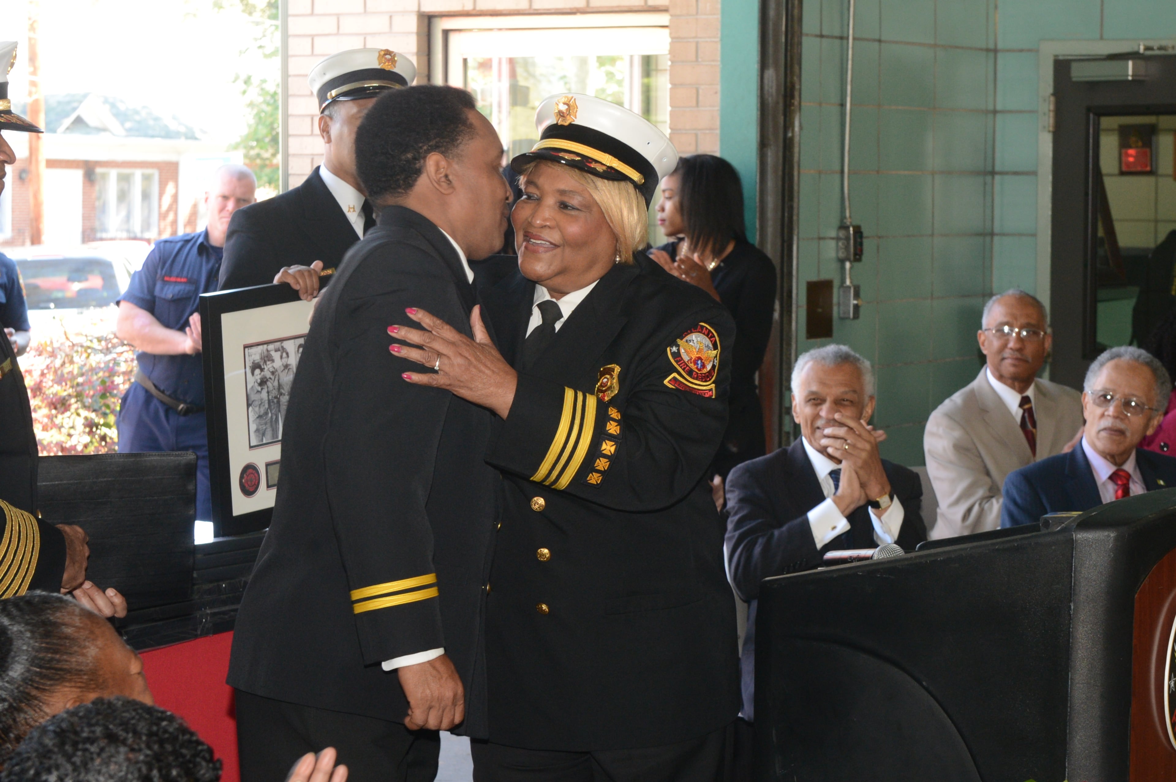 Retired AFR battallion chief Liz Summers hugs her son, Capt Irving Reese, also with Atlanta Fire Rescue during the ceremony Monday.
