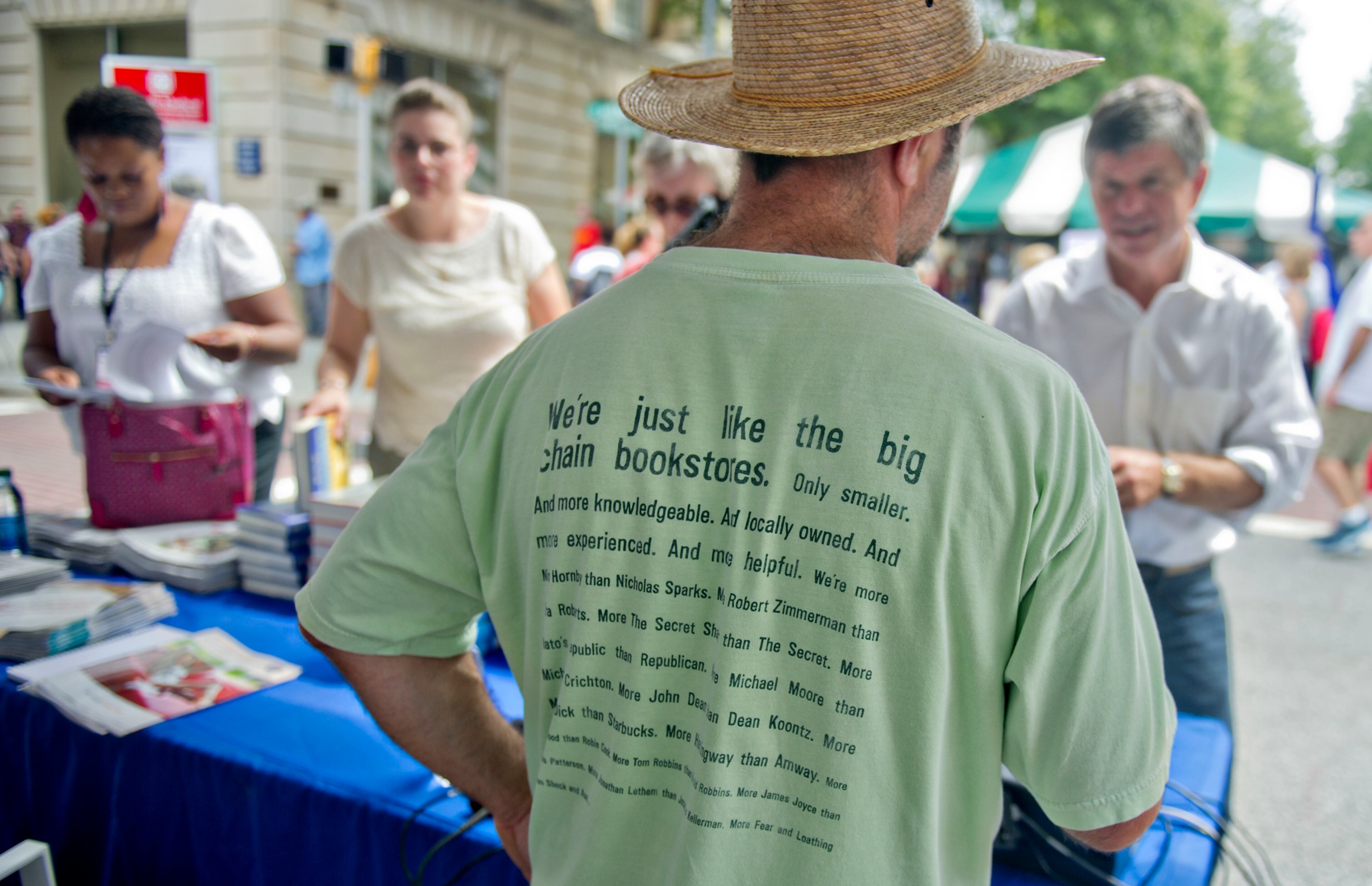 Decatur - Frank Reiss (center) helps customers at the Atlanta Journal-Constitution booth during the AJC Decatur Book Festival on Saturday, August 30, 2014. The annual festival draws visitors to downtown Decatur area to meet with world-class authors, illustrators, editors, publishers, booksellers, and artists for a weekend filled with literature, music, food, art, and fun. JONATHAN PHILLIPS / SPECIAL