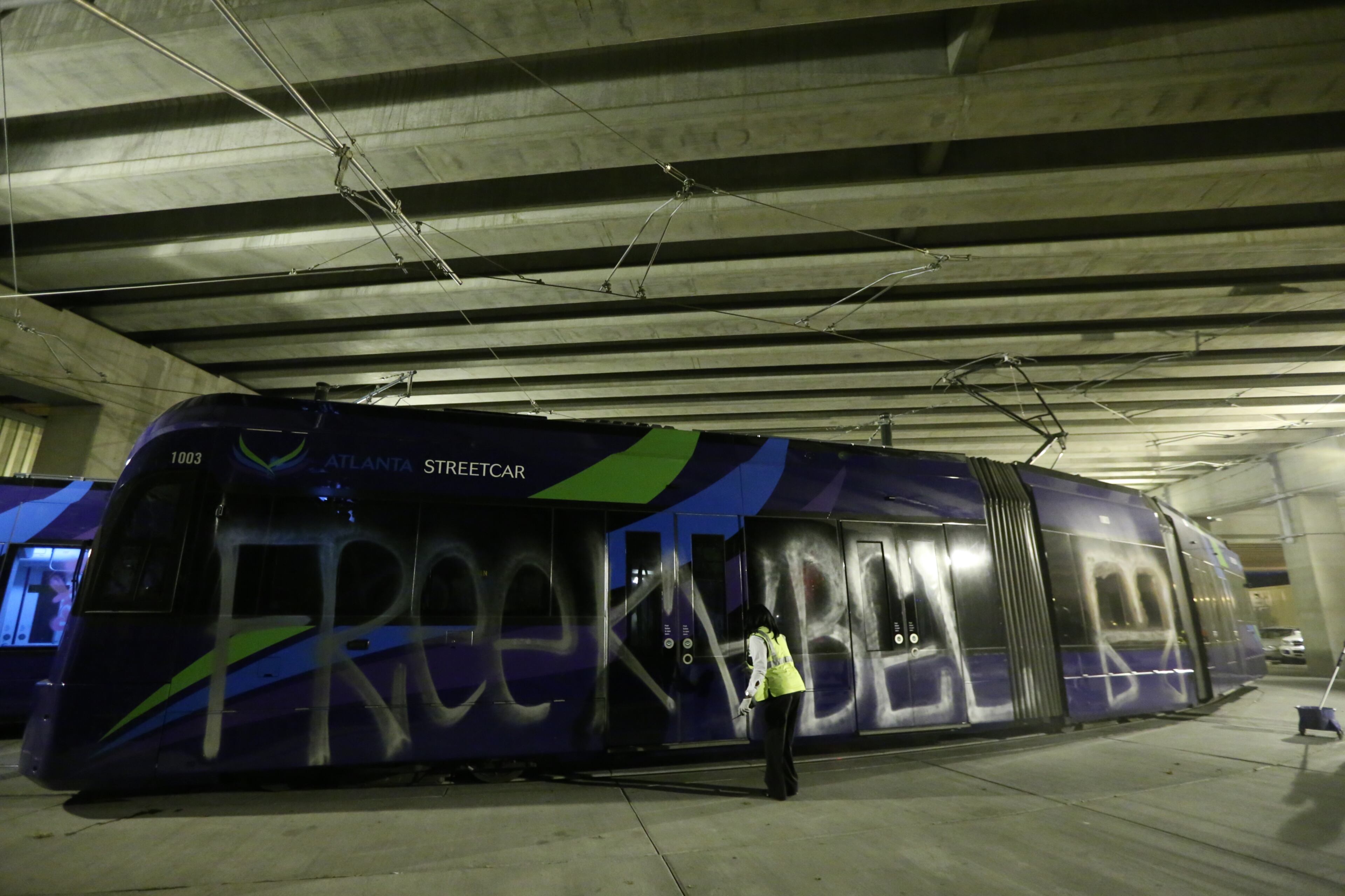 Cleanup begins early Tuesday morning, Sept. 22, 2016, on graffiti painted on the sides of Atlanta street cars. Police Tuesday were working to determine who vandalized several Atlanta streetcars overnight.The streetcars were spray painted with large graffiti while parked for the night at the streetcar maintenance barn under the Downtown Connector near Auburn and Edgewood avenues.The vandalism was reported to authorities about 3:30 a.m. Tuesday, according to Atlanta police dispatchers.
