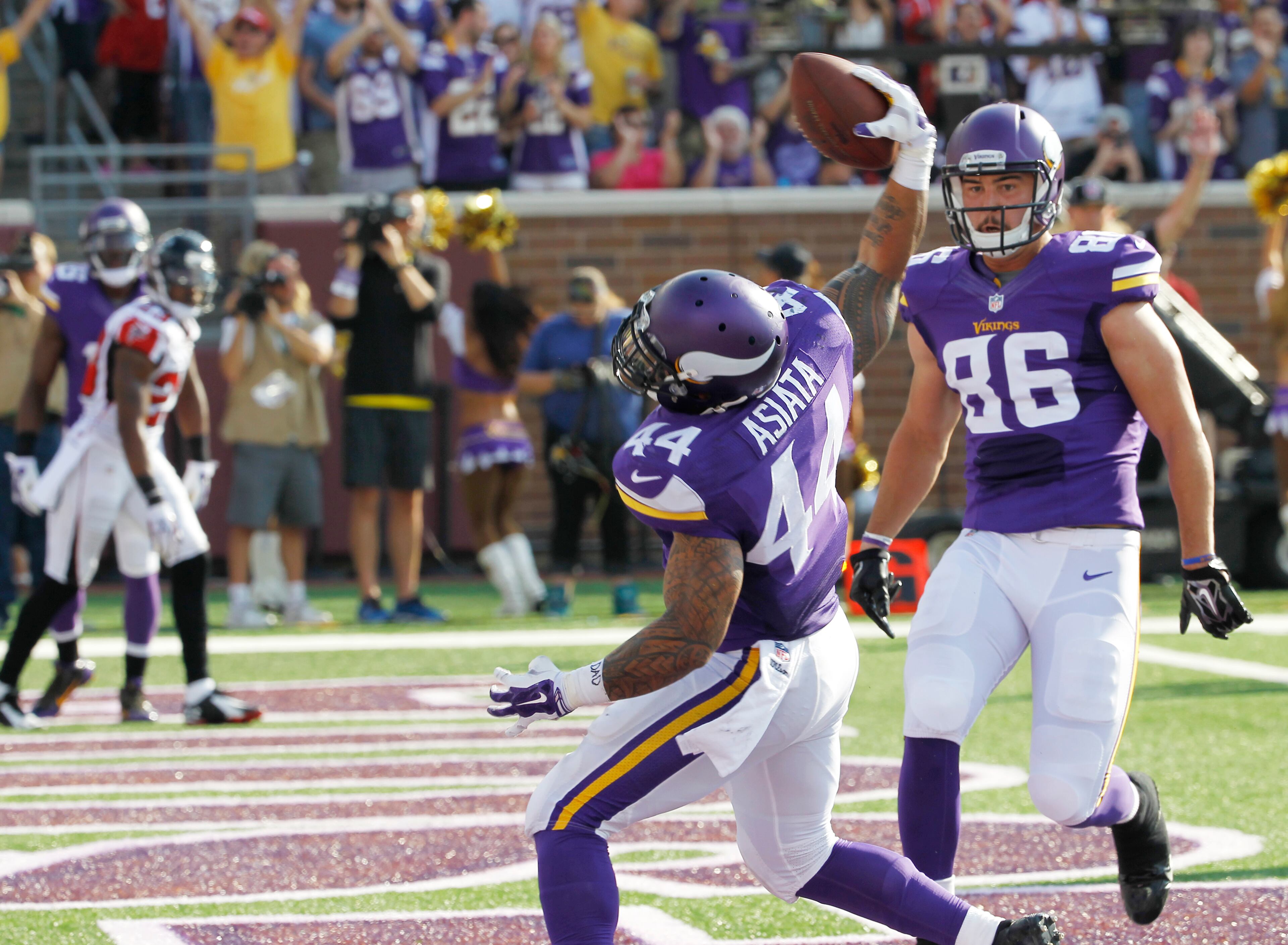 Minnesota Vikings running back Matt Asiata celebrates with teammate Chase Ford (86) after scoring on a 6-yard touchdown run in the first half of an NFL football game against the Atlanta Falcons, Sunday, Sept. 28, 2014, in Minneapolis. (AP Photo/Ann Heisenfelt)