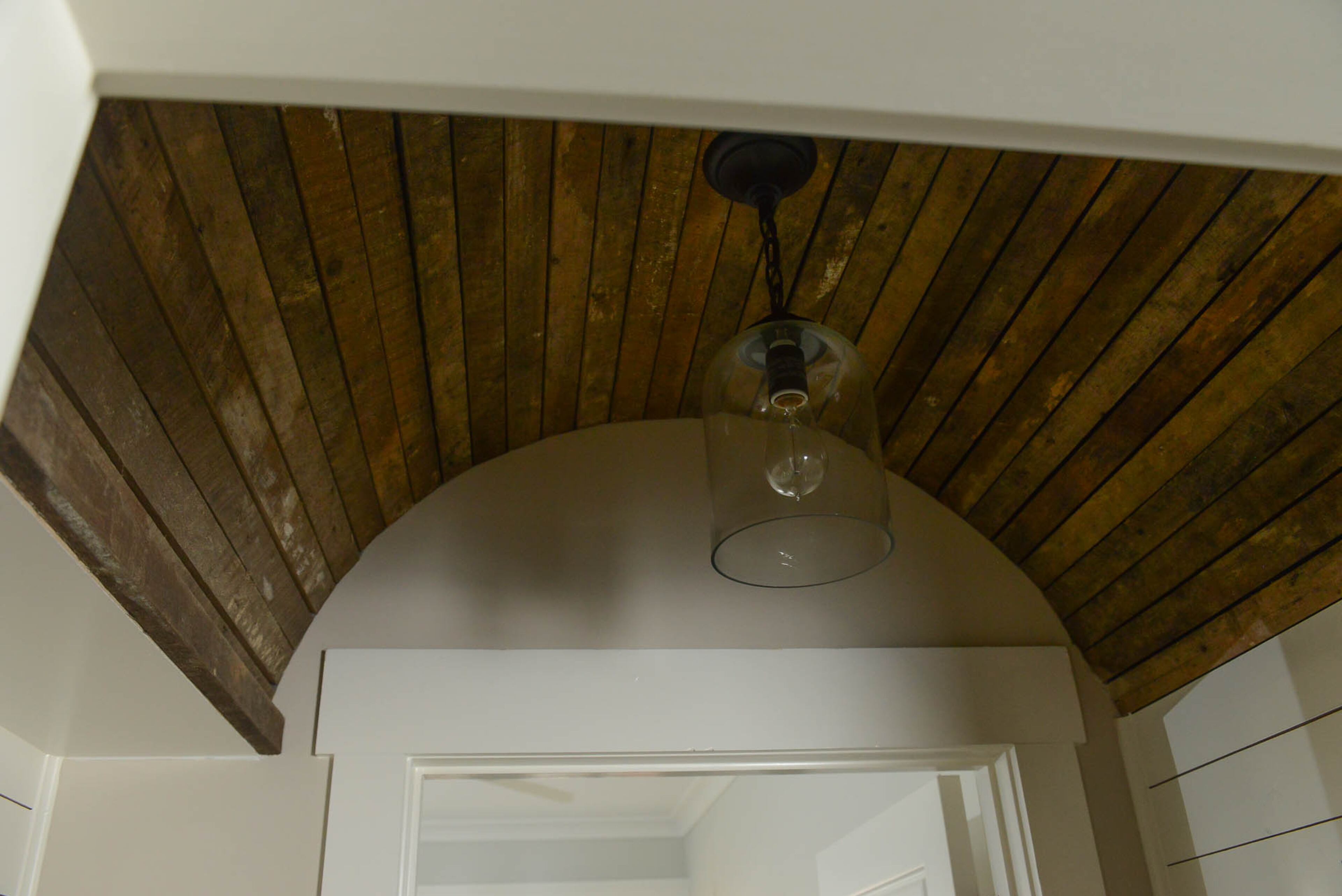 One of Kate’s favorite architectural details is the reclaimed wood arched ceiling in the hallway to her master bedroom, installed by builder Patrick Lockman in 2015. A pendant light from Progressive Lighting contrasts with the rustic wood to balance the space.