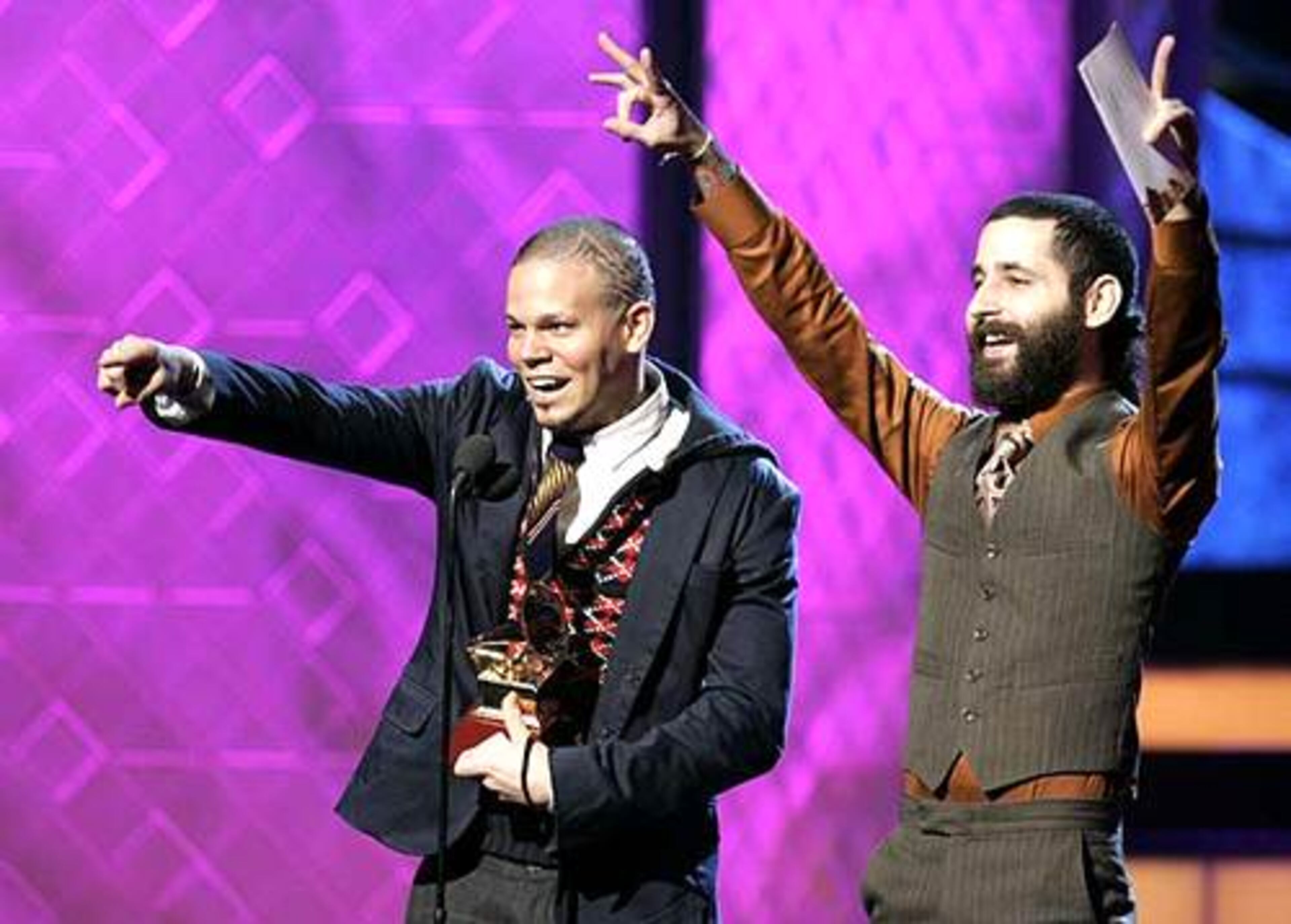 Residente, left, and Visitante, of Calle 13, accept the award for best urban music album for Residente O Visitante.