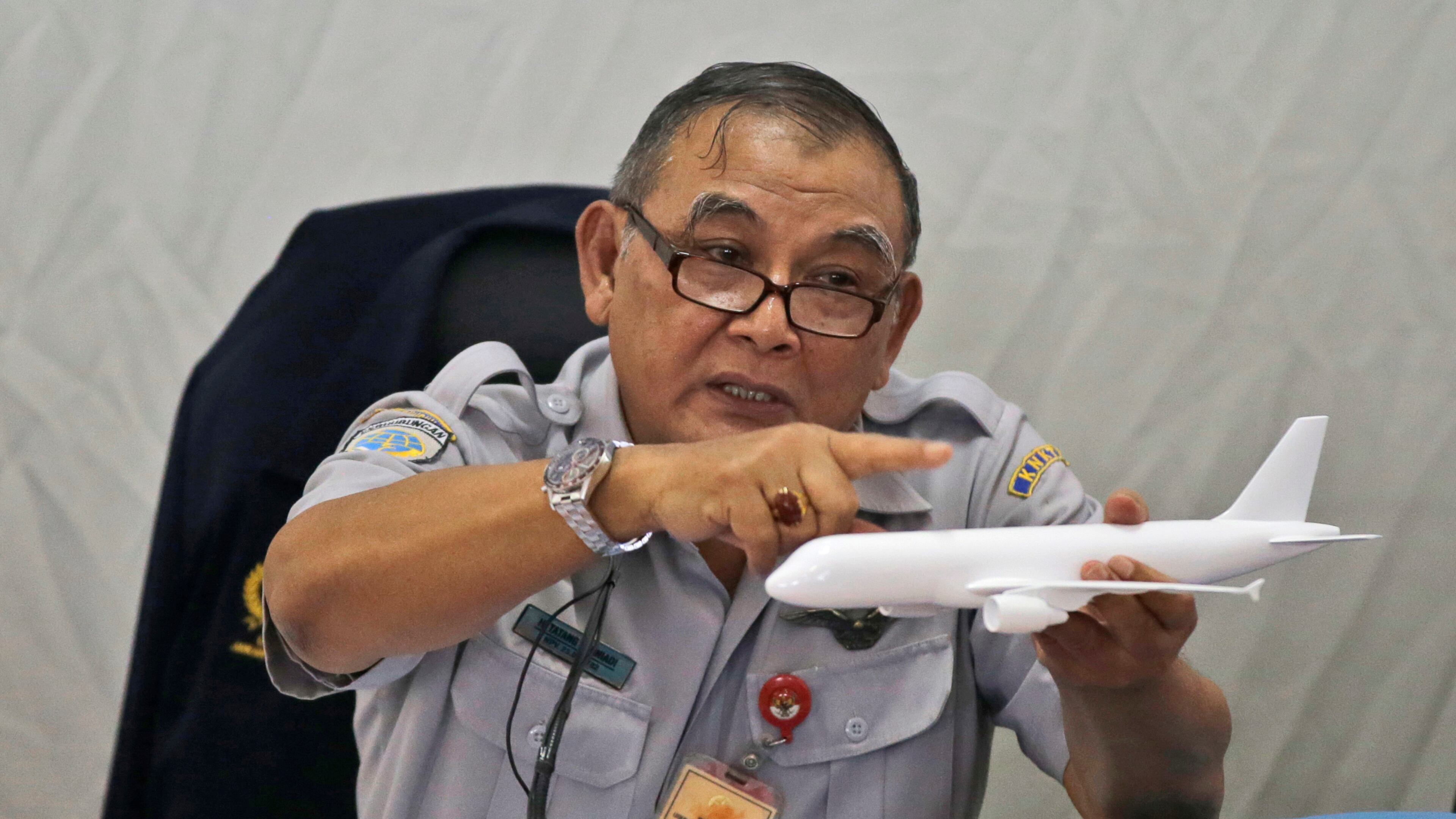 Indonesian National Transportation Safety Committee chief Tatang Kurniadi speaks with a model plane of AirAsia Flight 8501 that crashed into the Java Sea on Dec. 28 last year during a press conference in Jakarta, Indonesia Thursday, Jan. 29, 2015. On Dec. 1, 2015, an investigation concluded that at least one faulty plane part and crew behavior led to the plane going down, killing everyone on board. (AP Photo/Dita Alangkara)
