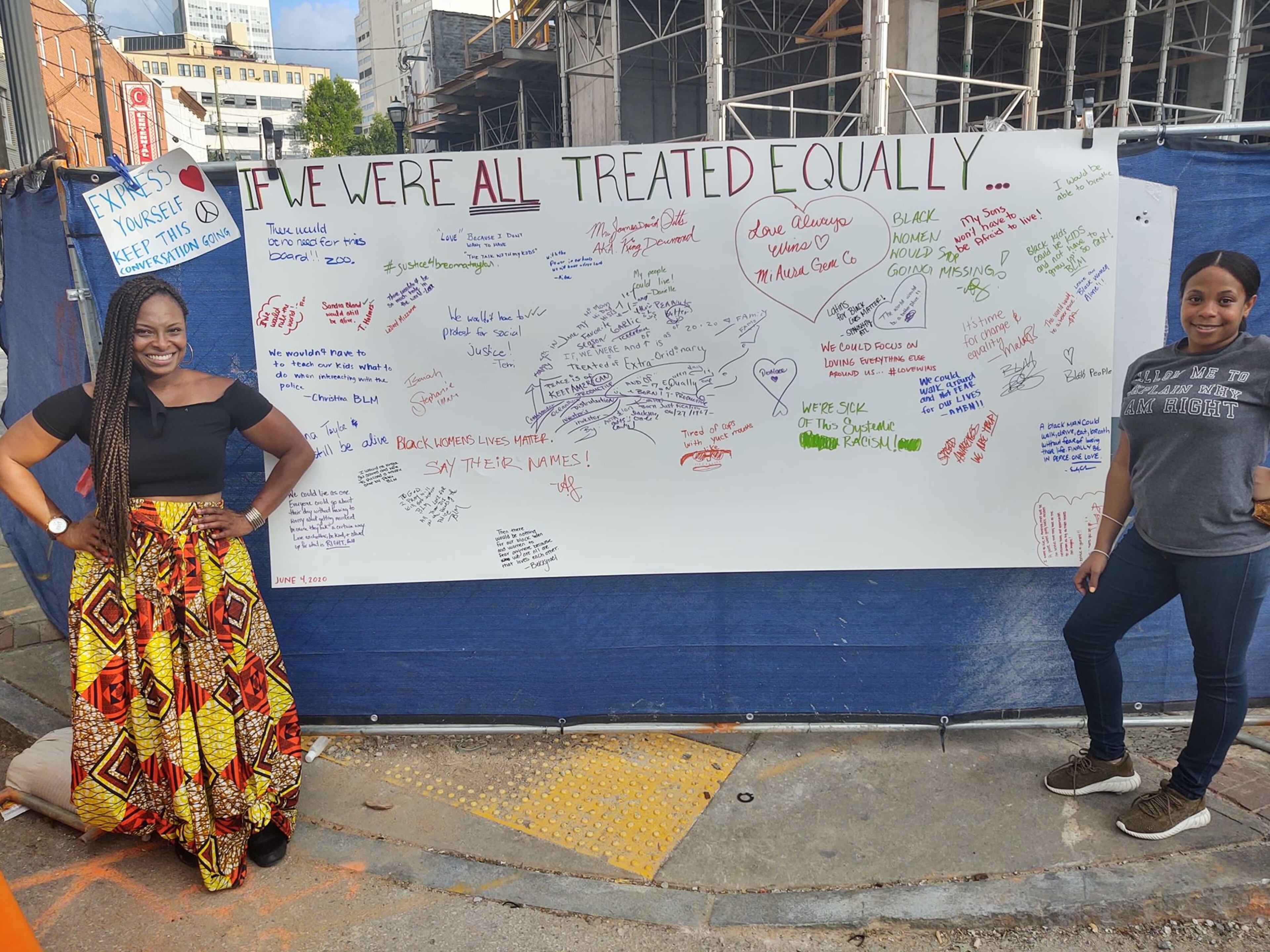 Amisha Harding, left, and her cousin Samantha Harding, have been bringing a "healing wall" to the downtown protests for people to sign. But she still fears for the safety of her 18-year-old son.