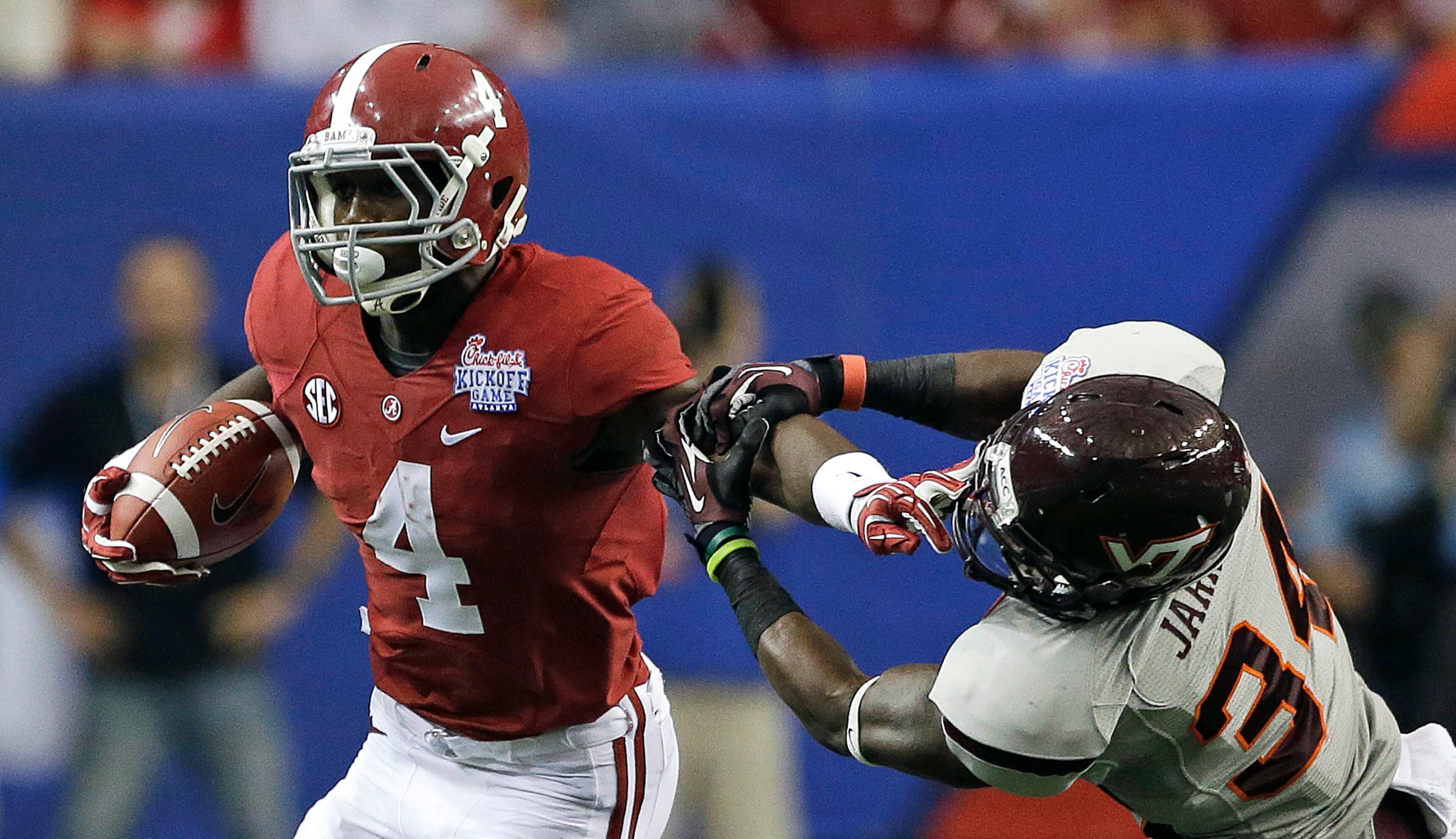 Alabama running back T.J. Yeldon (4) stiffs arm Virginia Tech safety Kyshoen Jarrett (34) in the first half of an NCAA college football game, Saturday, Aug. 31, 201, in Atlanta. (AP Photo/Dave Martin)