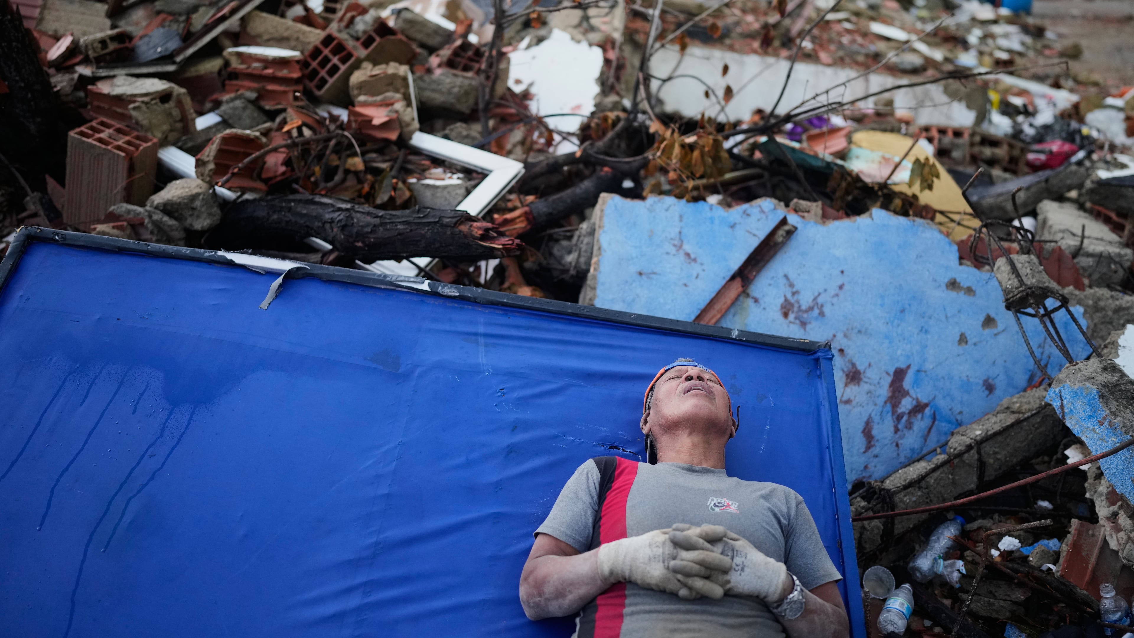 Resident Kerli Faria takes a break amid the rubble while searching for her nephews at a building that collapsed during the earthquakes that struck La Guaira, Venezuela, Tuesday, June 30, 2026. (AP Photo/Ariana Cubillos)