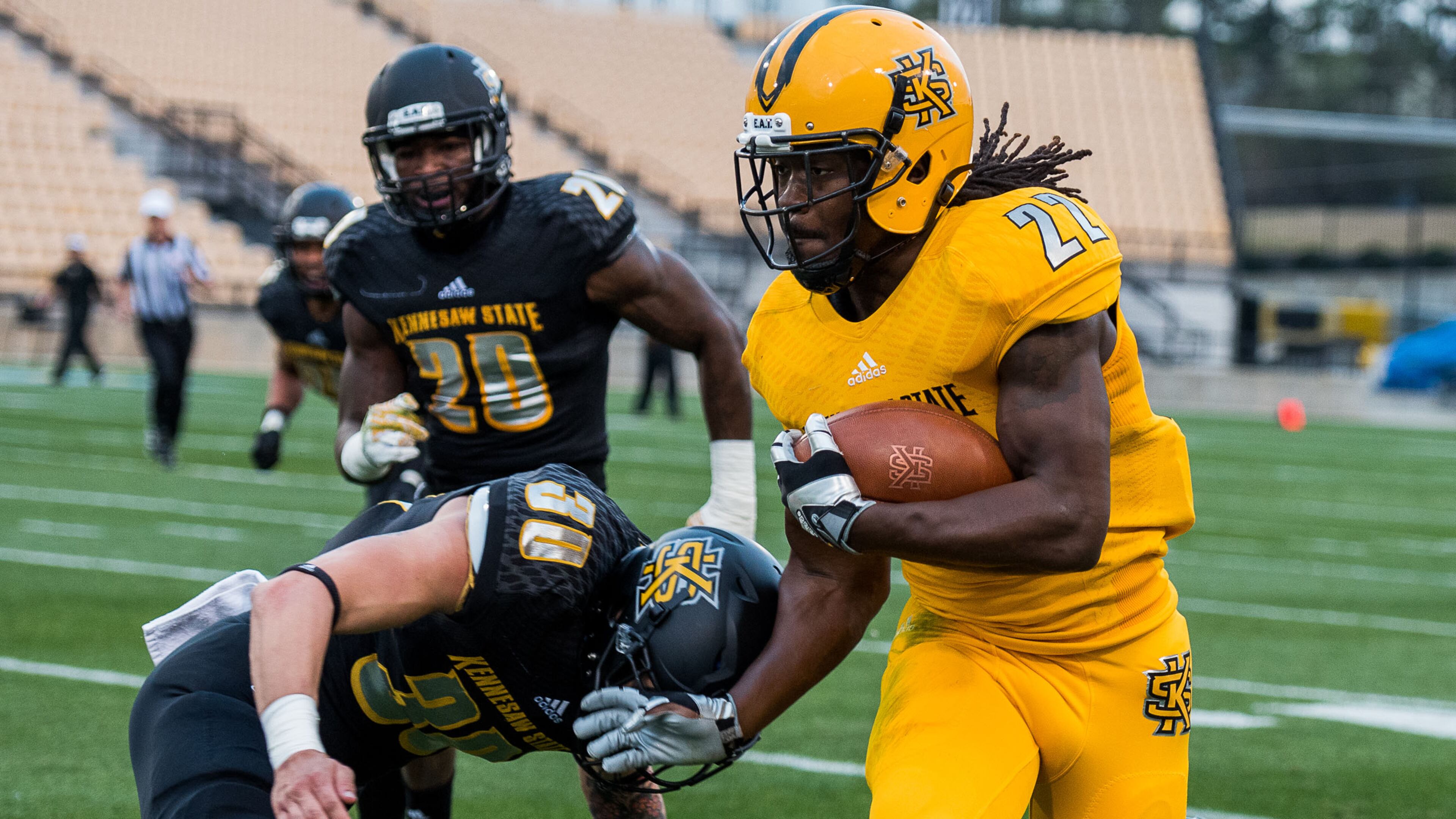 Running back Trey Chivers (22) tries to evade a tackle from Dustin Clabough (30) during the 2017 Kennesaw State spring football game.
